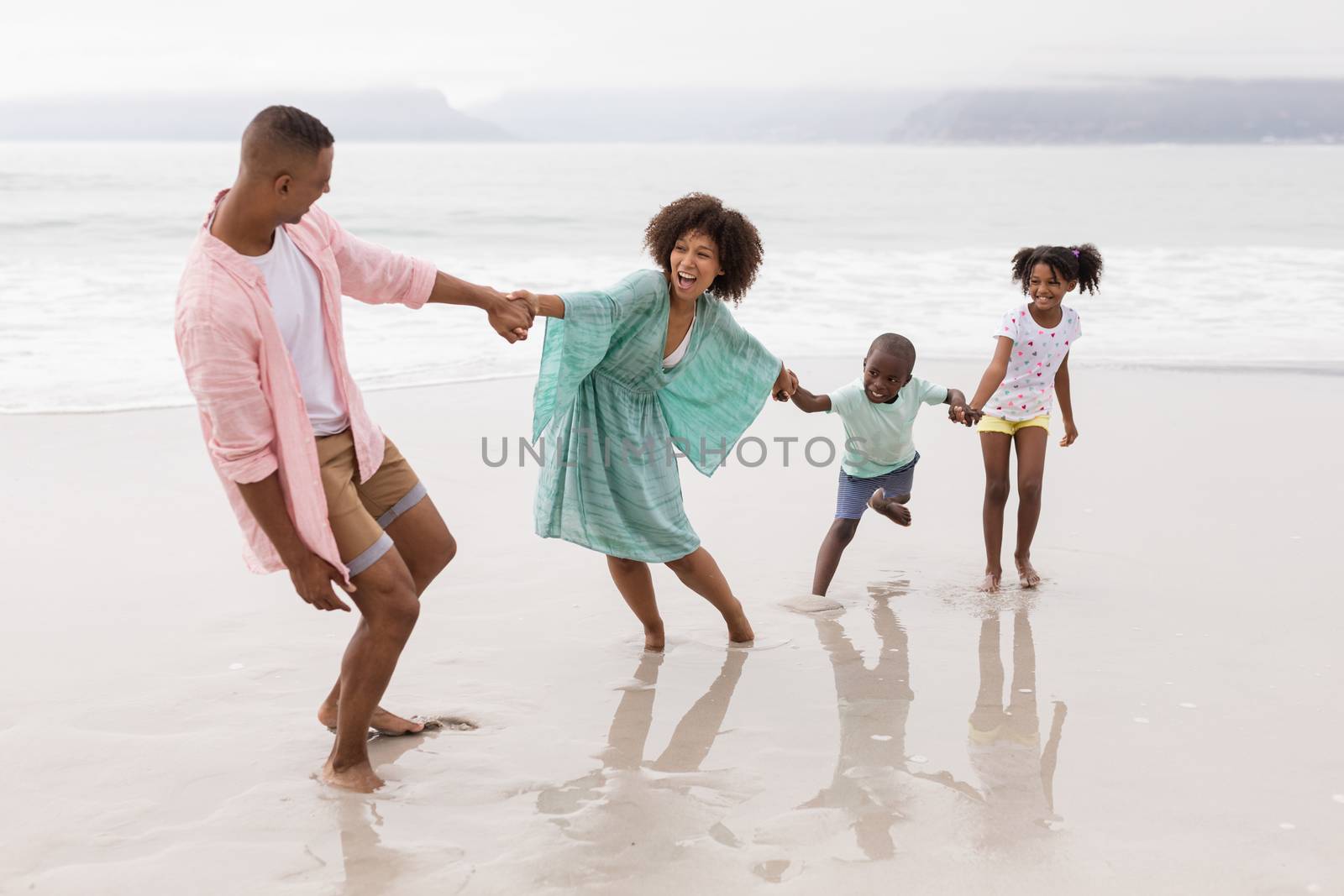 Family having fun on the beach by Wavebreakmedia
