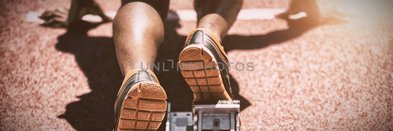 Feet of an athlete on a starting block about to run, Close-up