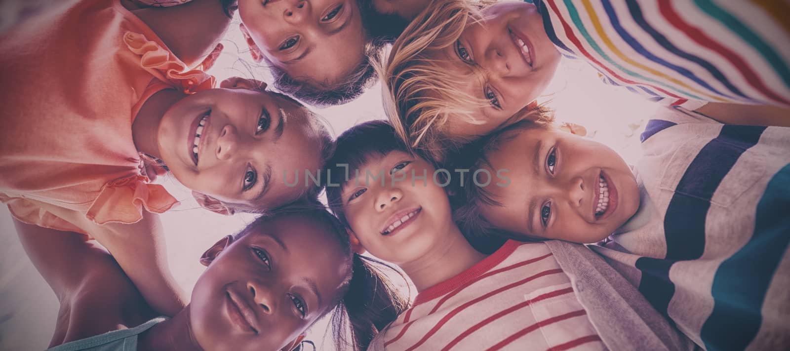 Portrait of schoolkids forming huddle on a sunny day