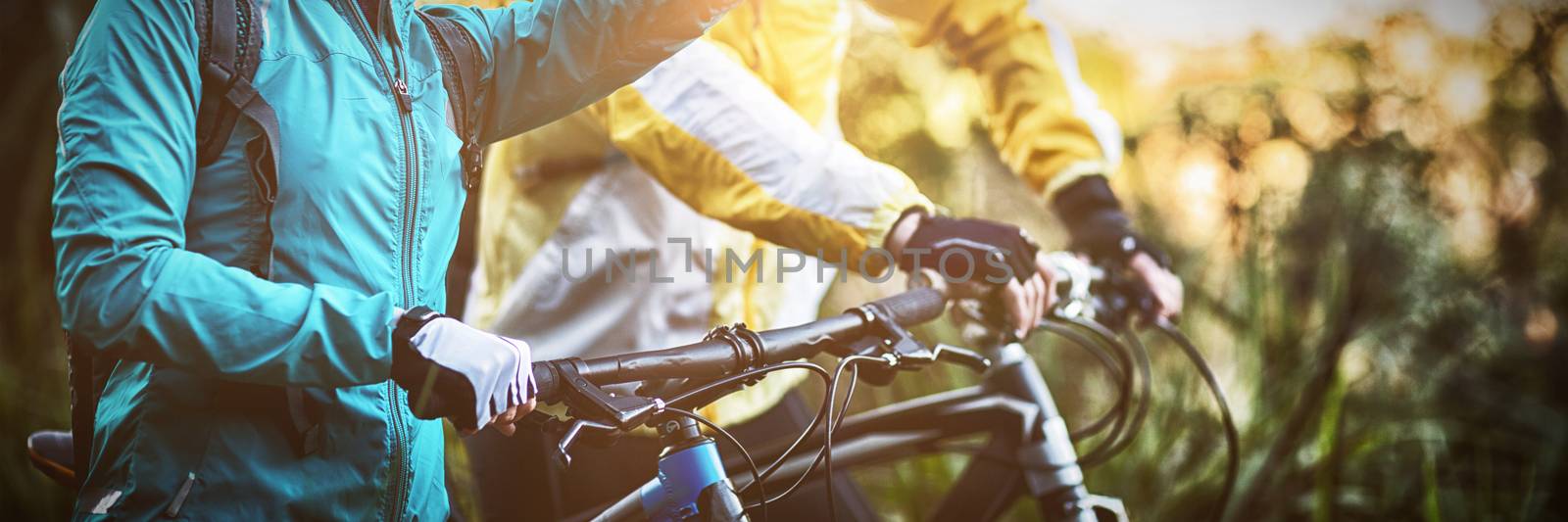 Biker couple with mountain bike pointing in distance by Wavebreakmedia