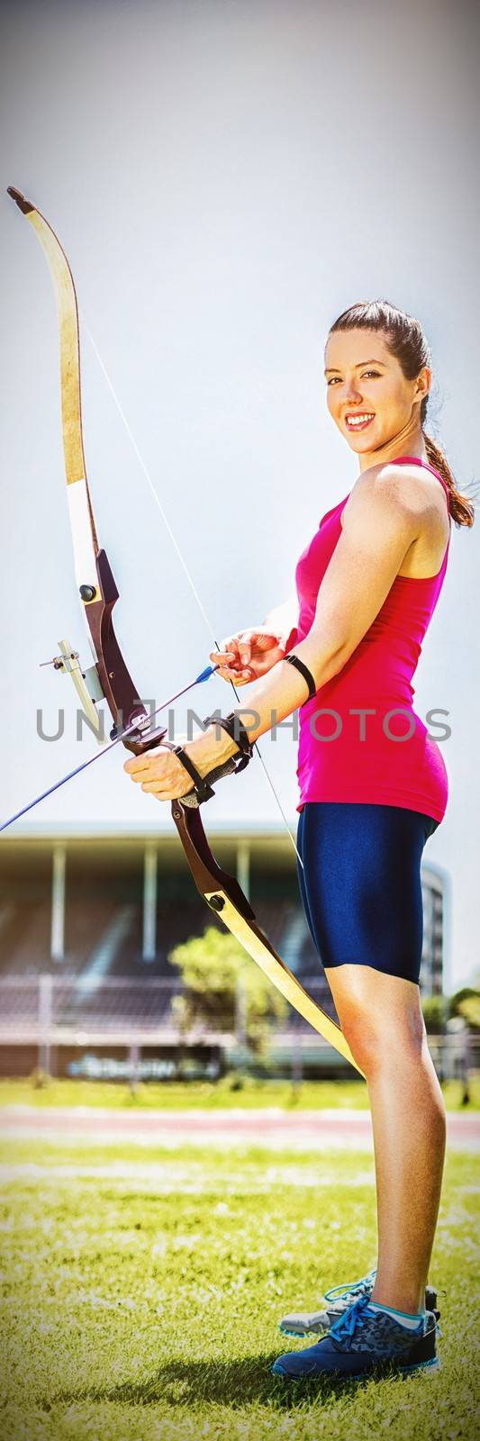 Portrait of female athlete practicing archery in stadium