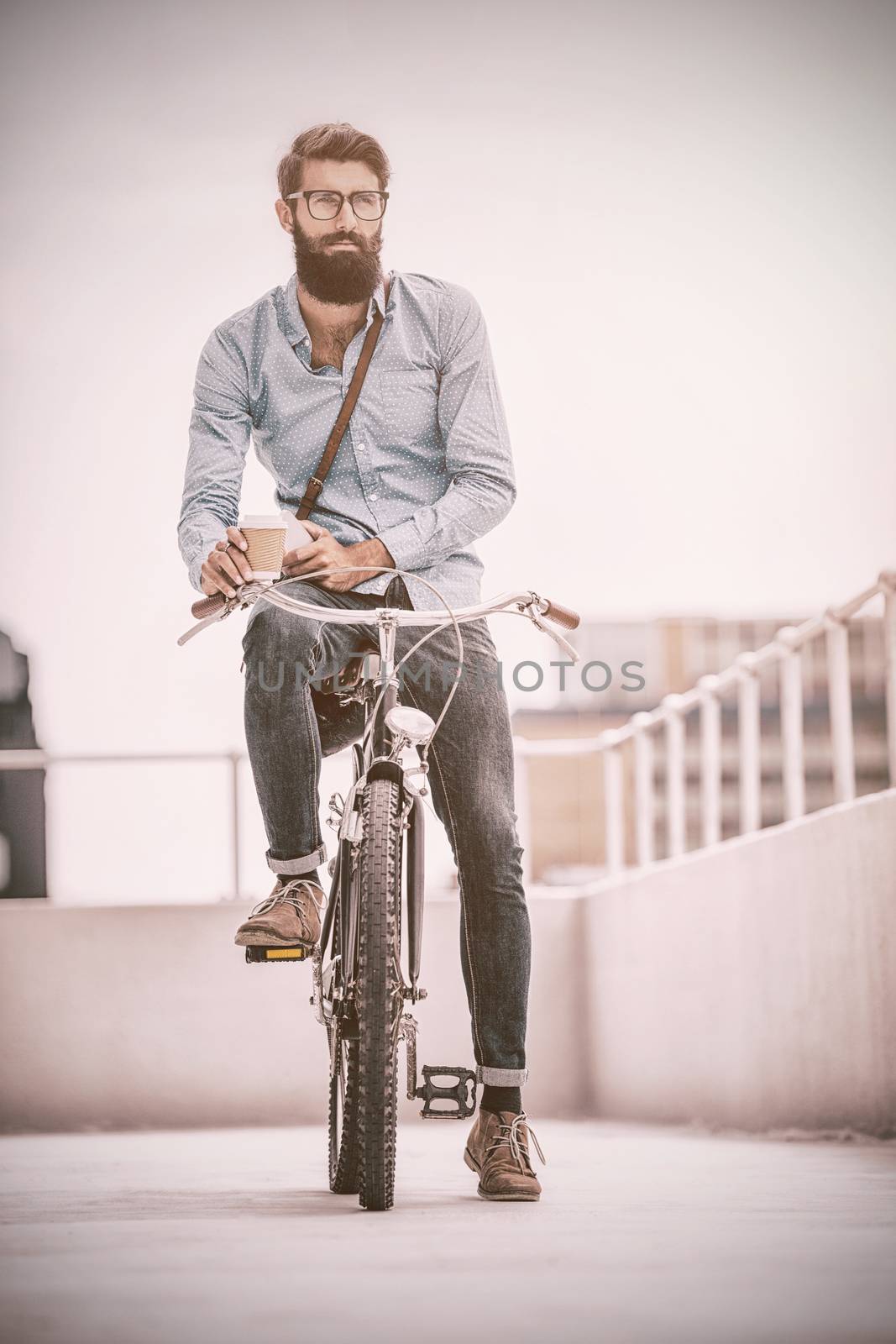 Hipster posing on his bike in a balcony