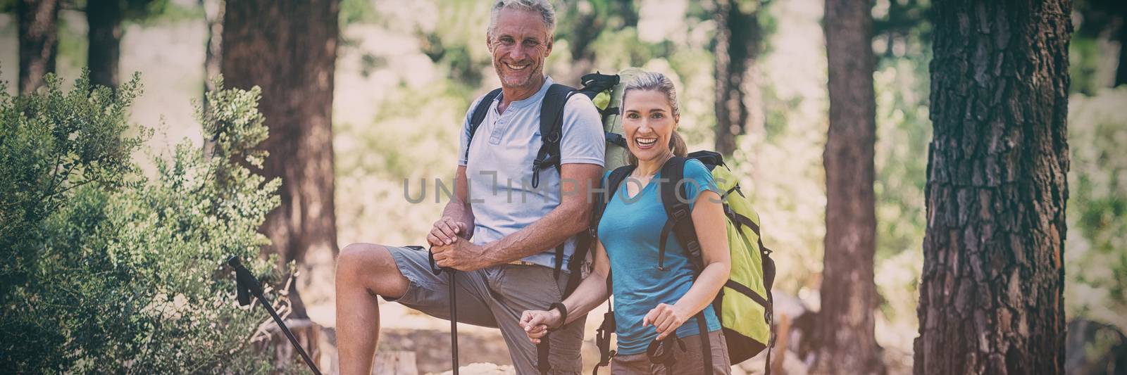 Couple smiling and posing during a hike  by Wavebreakmedia