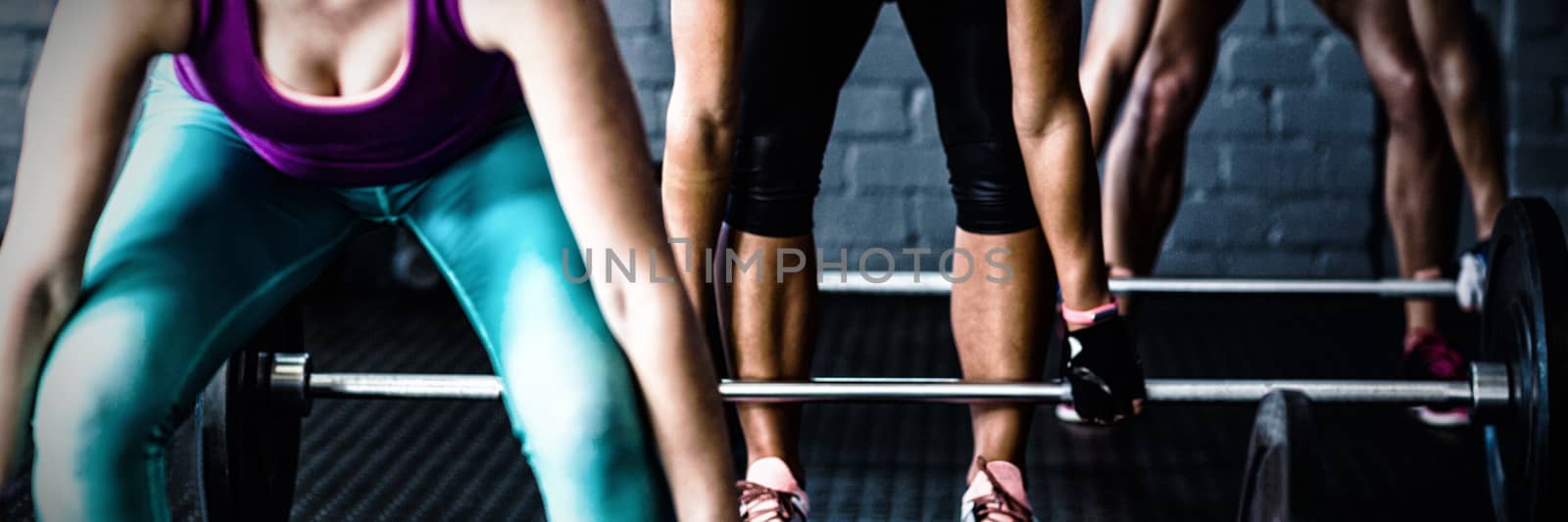 Female athletes lifting barbells in gym