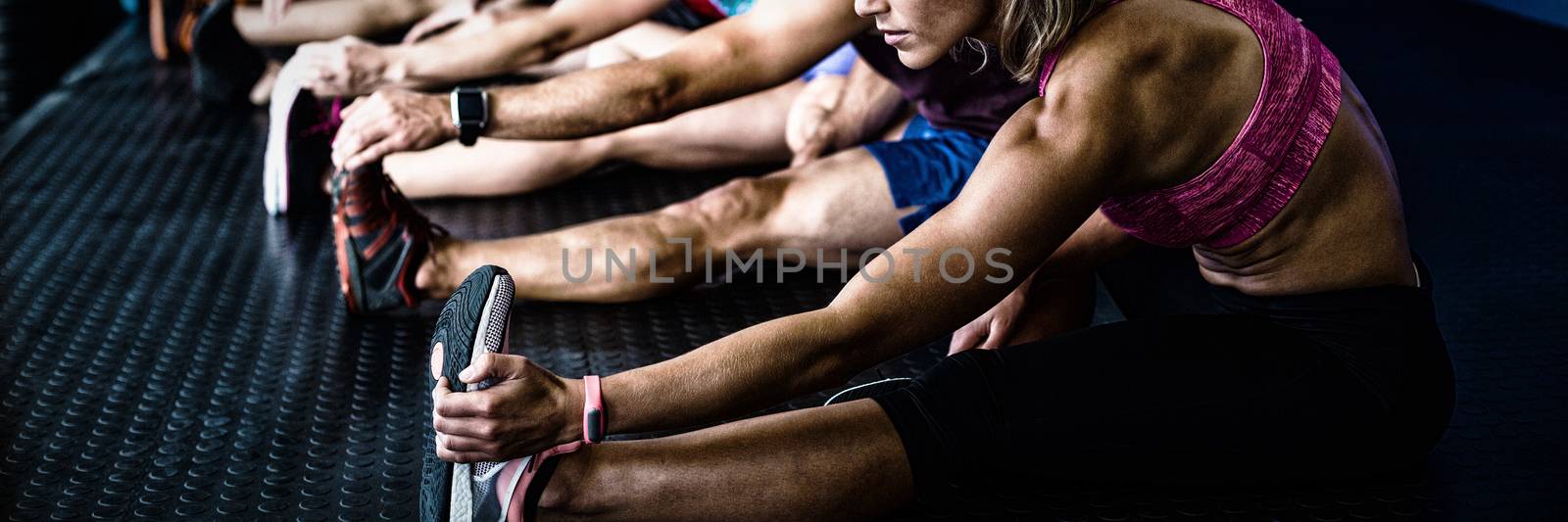 Side view of athletes stretching by Wavebreakmedia