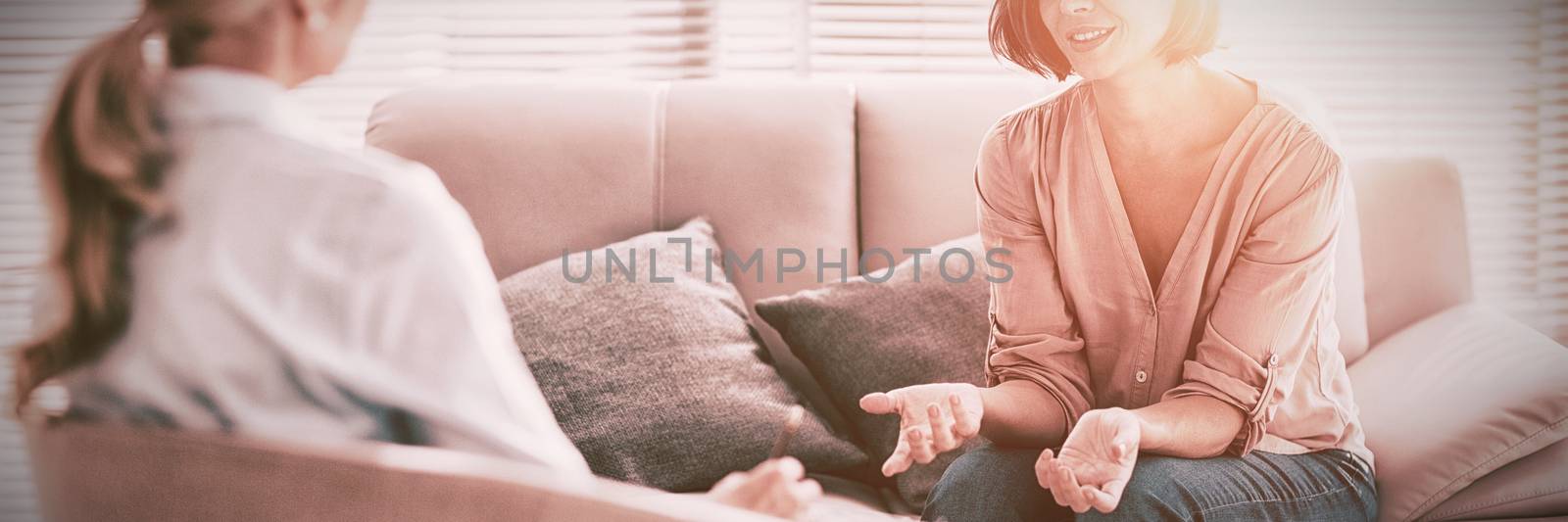 Woman talking to therapist on sofa at home