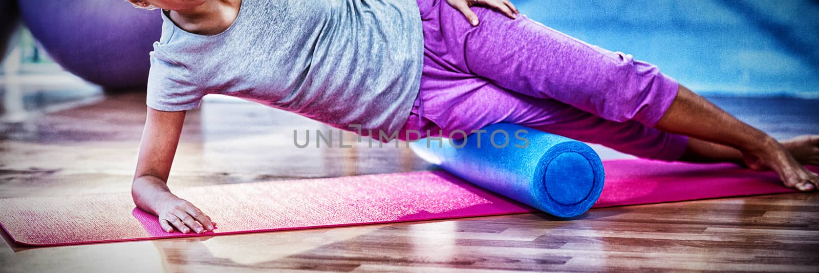 Woman performing exercise using foam roll by Wavebreakmedia