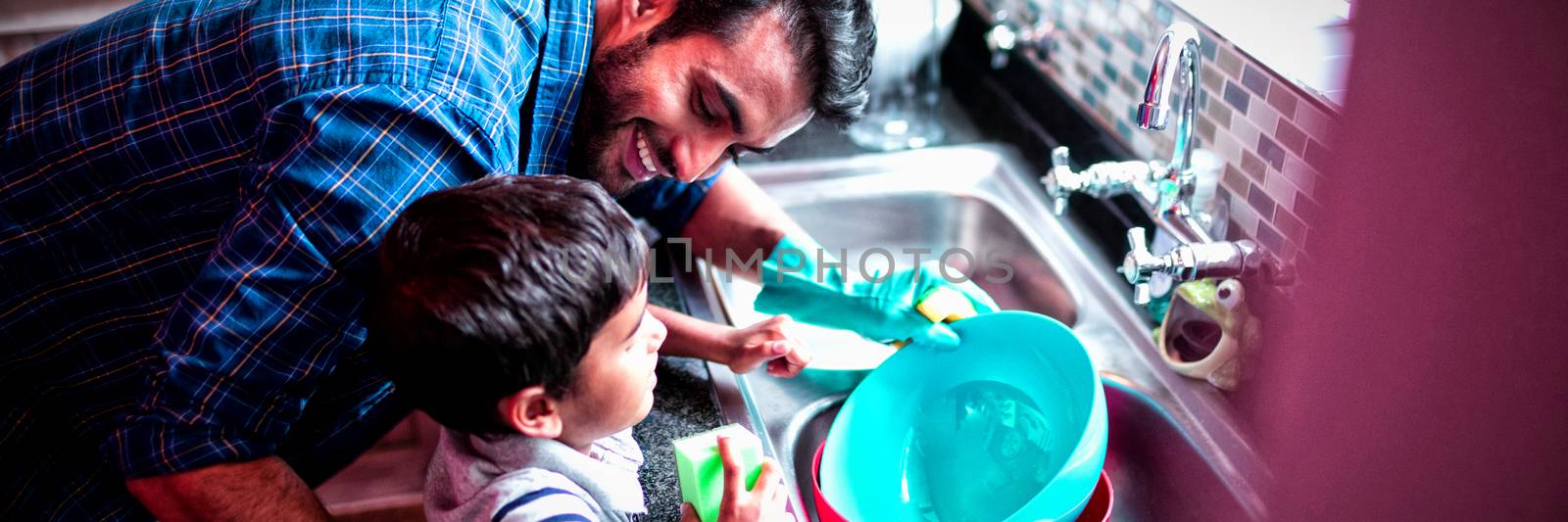 Father and son cleaning utensils at home by Wavebreakmedia