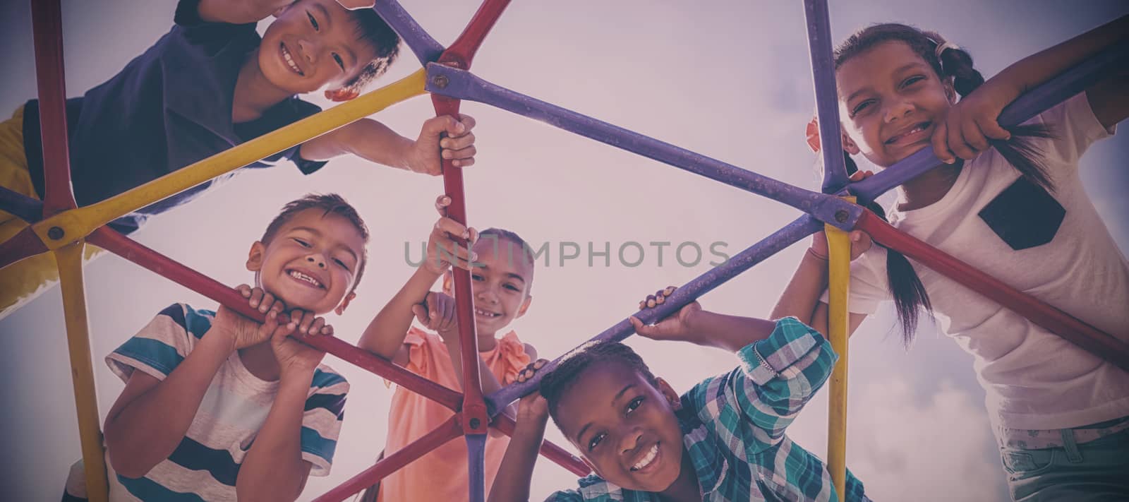 Portrait of happy schoolkids looking through dome climber by Wavebreakmedia