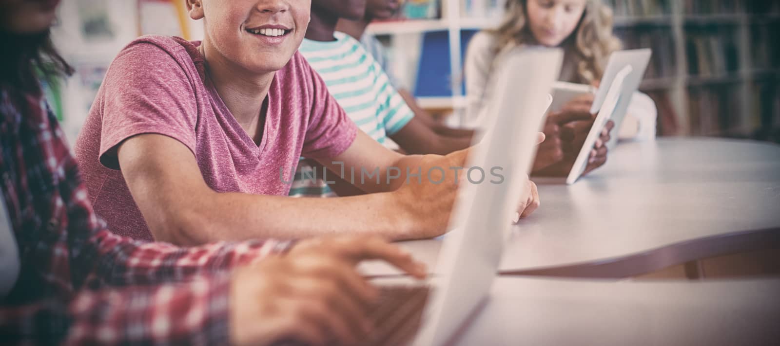 Students using laptop, digital tablet by Wavebreakmedia