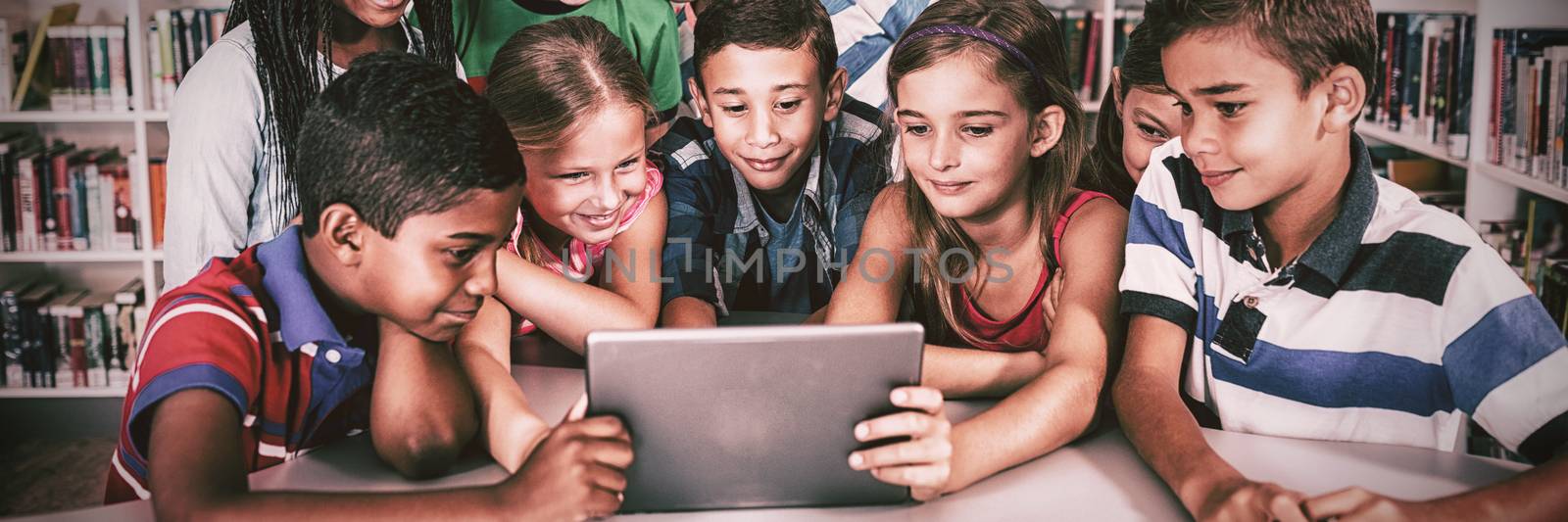 Front view of pupils using tablet pc in library