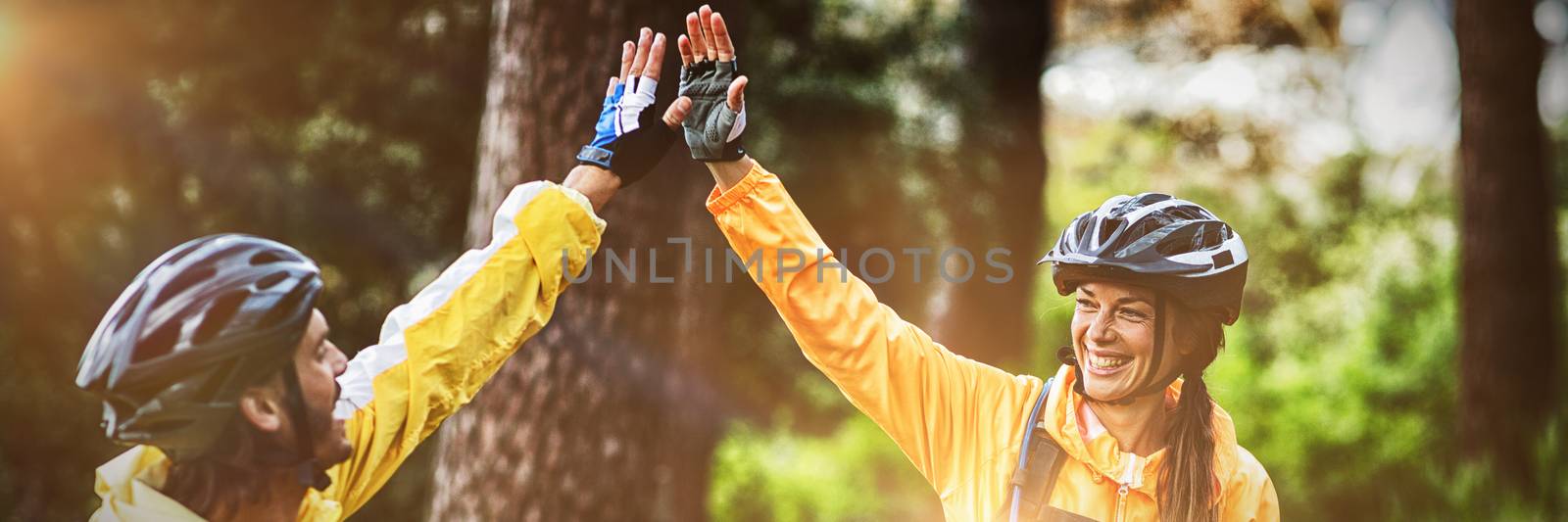 Happy biker couple giving high five each other in countryside