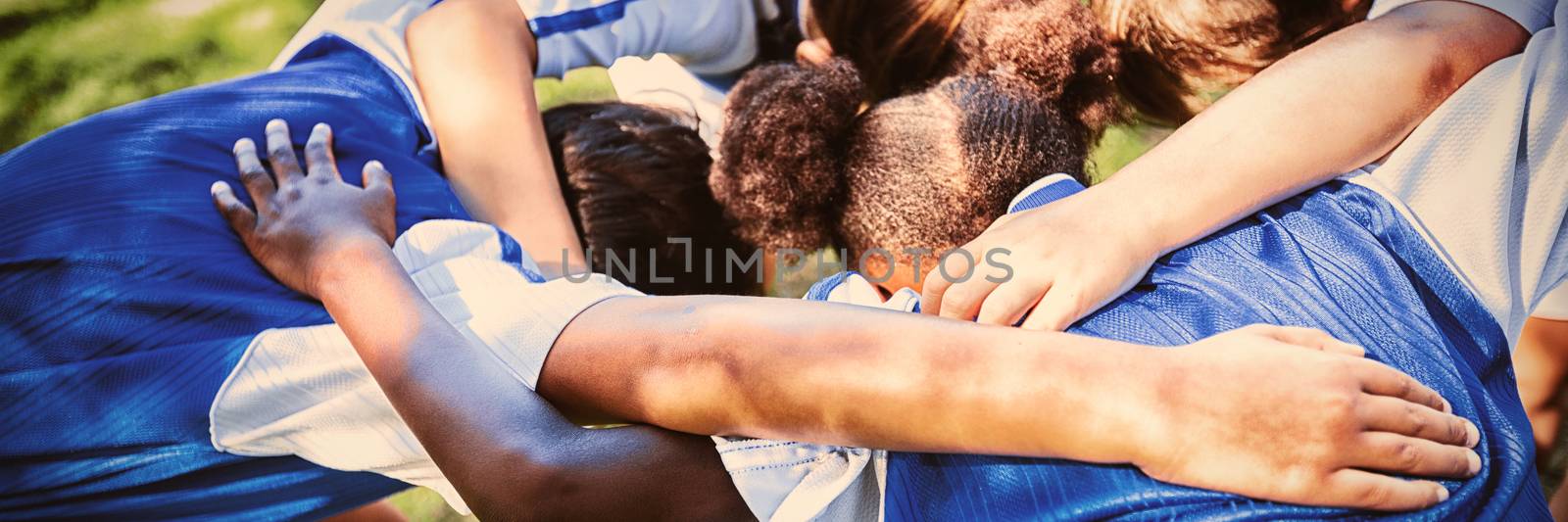 Rear view of soccer team forming huddle  by Wavebreakmedia