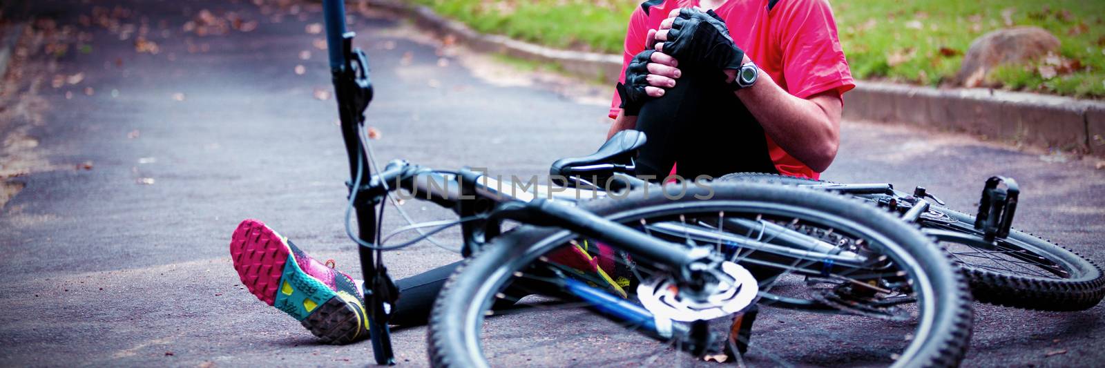 Male cyclist getting injured while falling from mountain bike by Wavebreakmedia