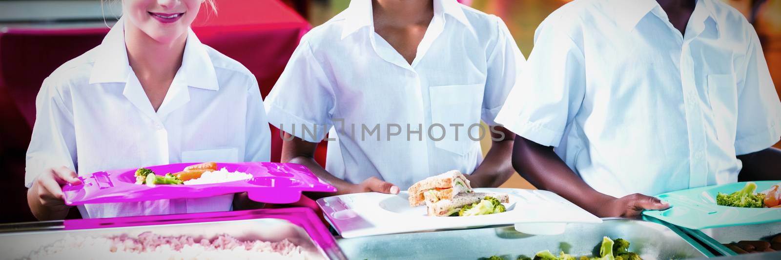 Portrait of school kids having lunch during break time in school cafeteria