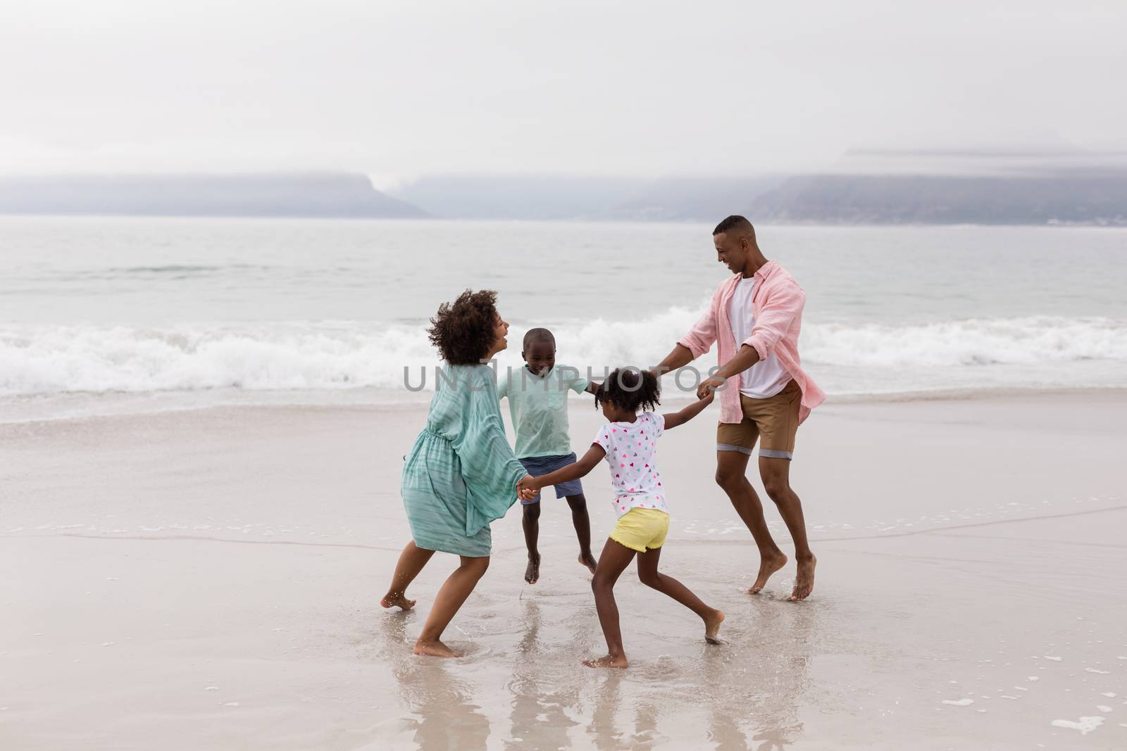 Family having fun on the beach by Wavebreakmedia