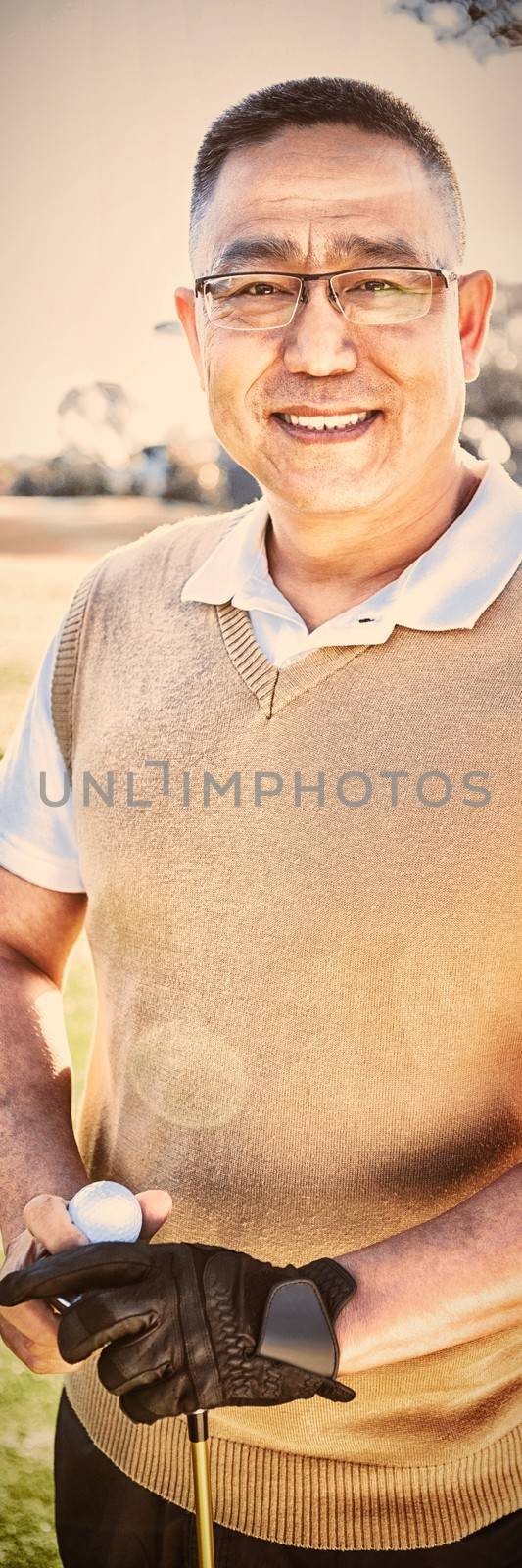 Portrait of golfer posing with a ball on a field