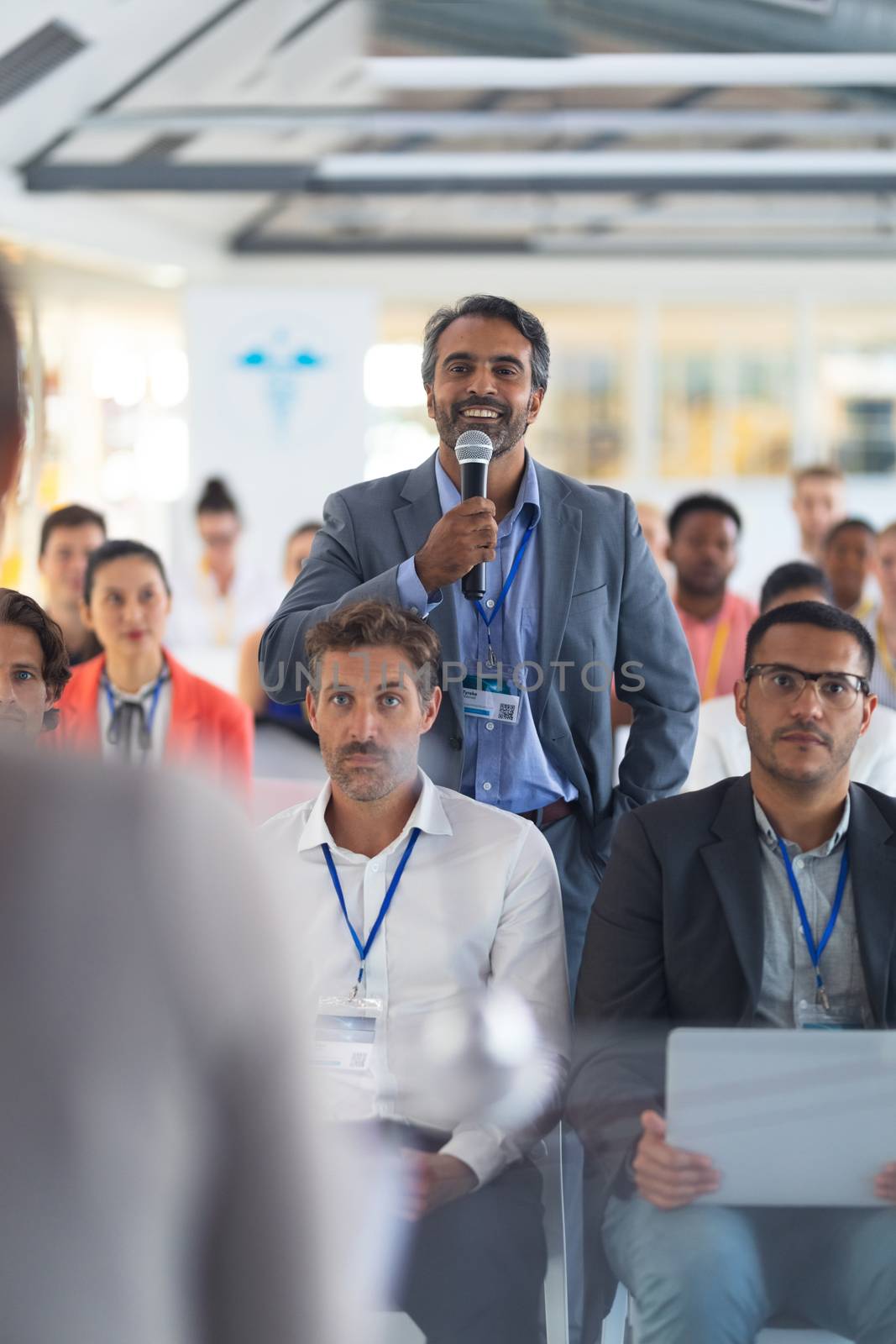 Front view of caucasian businessman asking question during seminar. International diverse corporate business partnership concept