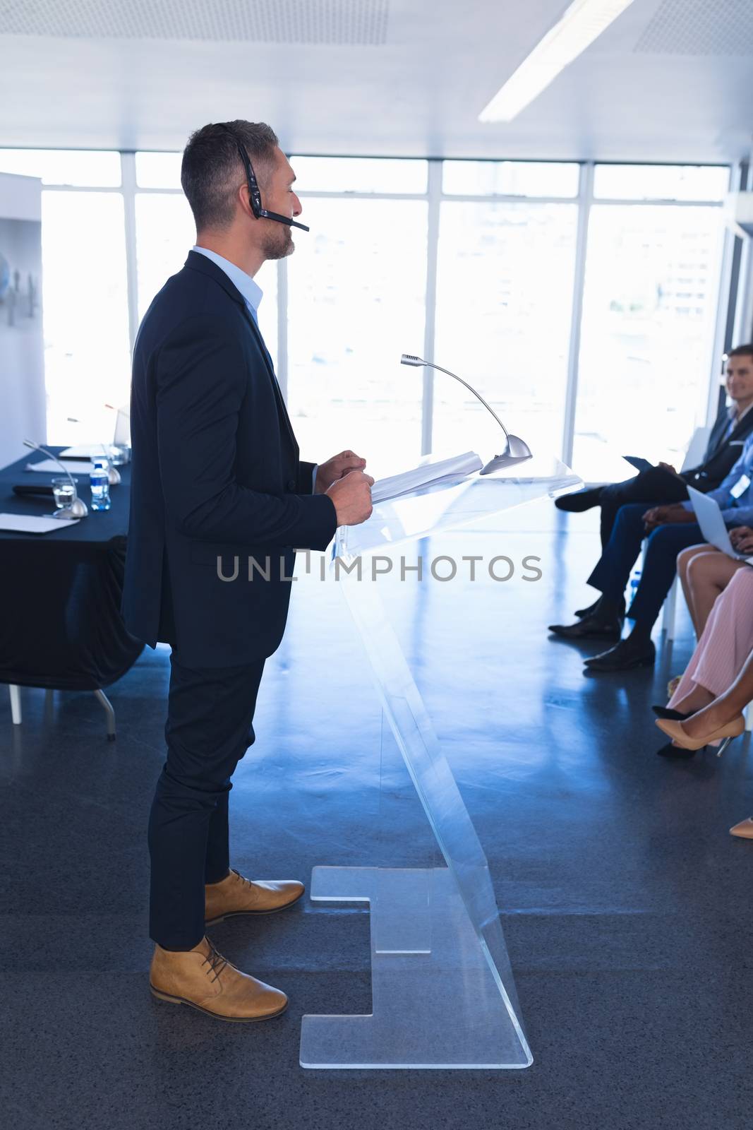 Side view of Caucasian Male speaker speaks in business seminar at conference meeting. International diverse corporate business partnership concept