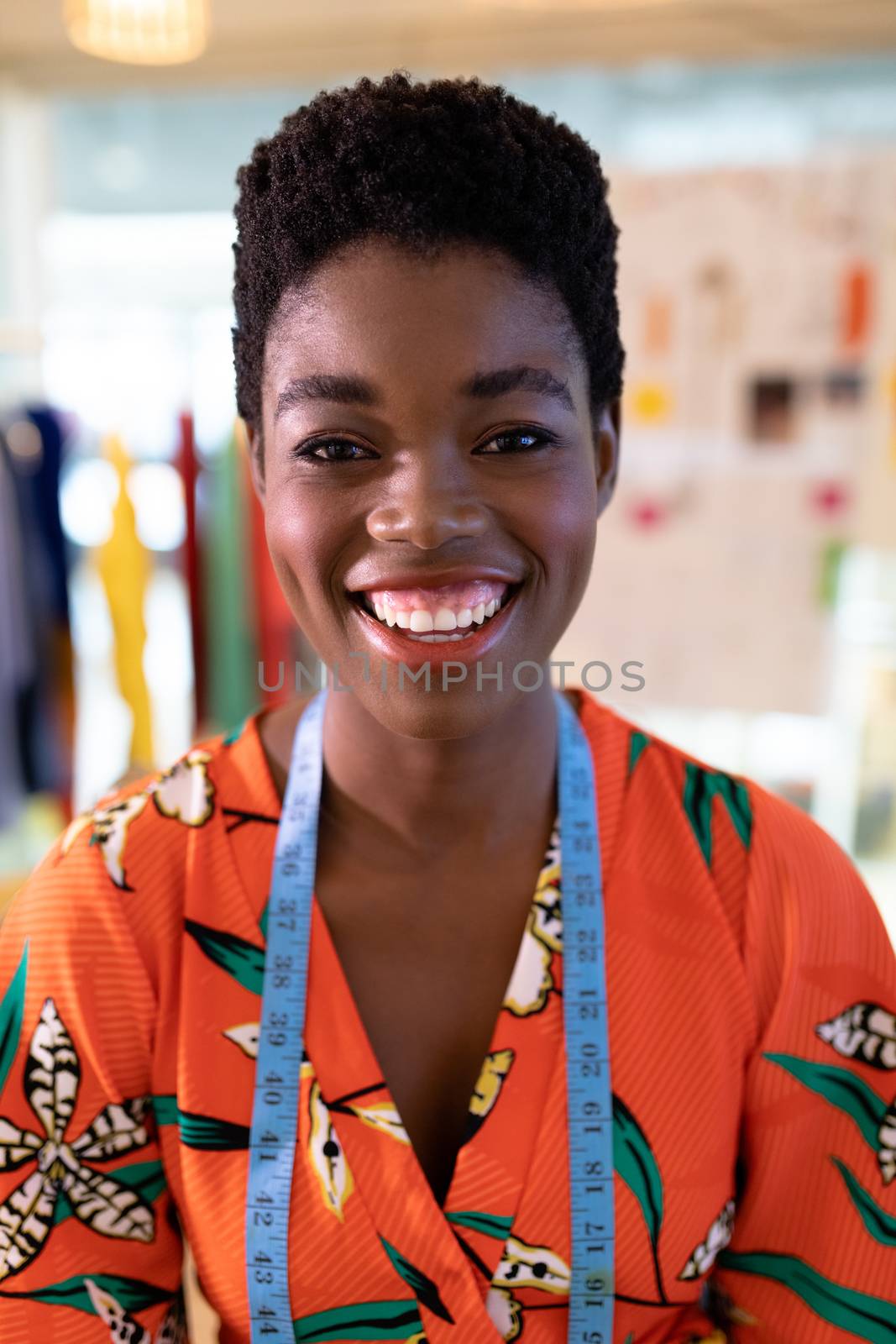 Portrait of young African american female fashion designer smiling in design studio. This is a casual creative start-up business office for a diverse team