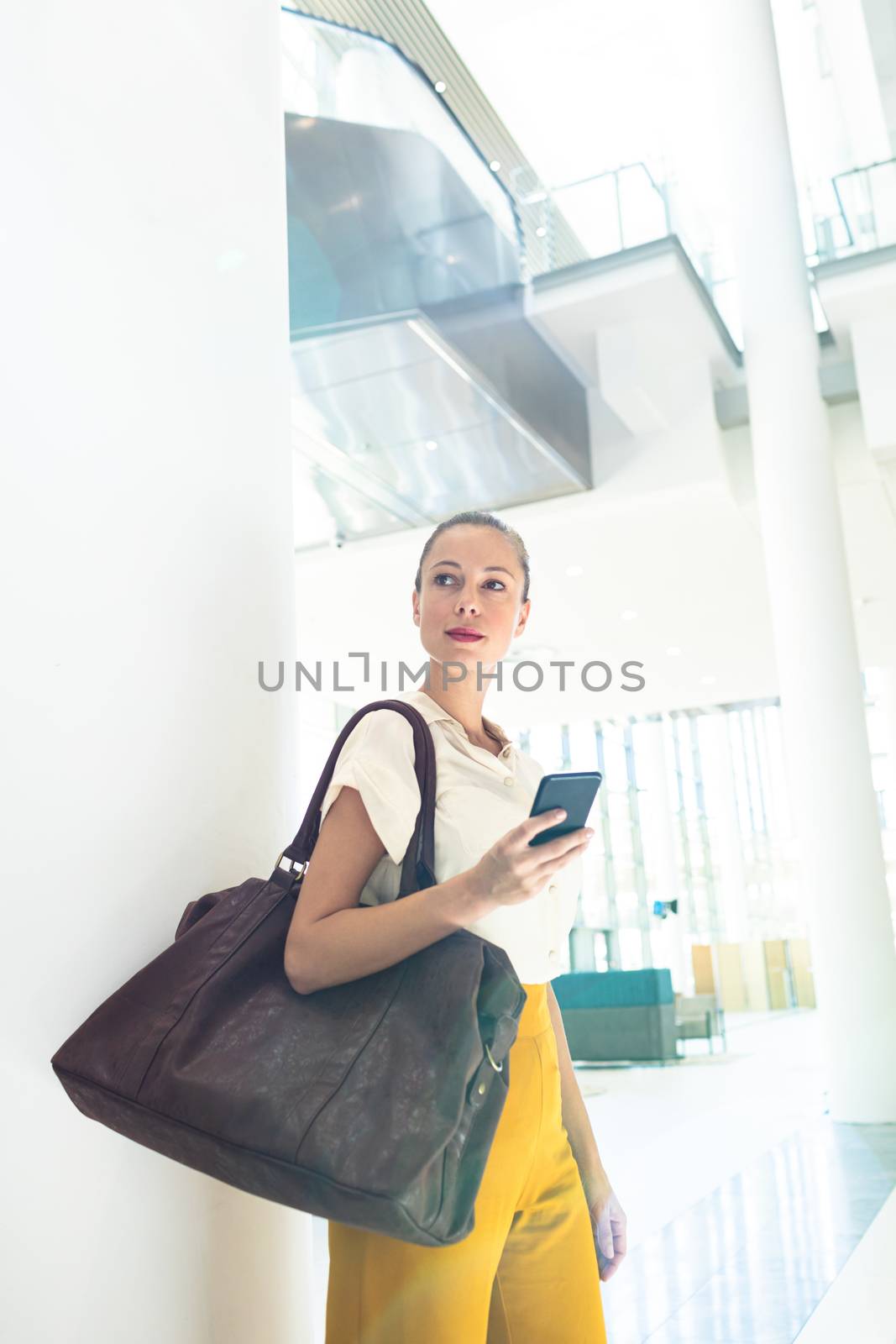 Side view of Caucasian female executive looking away while standing in modern office