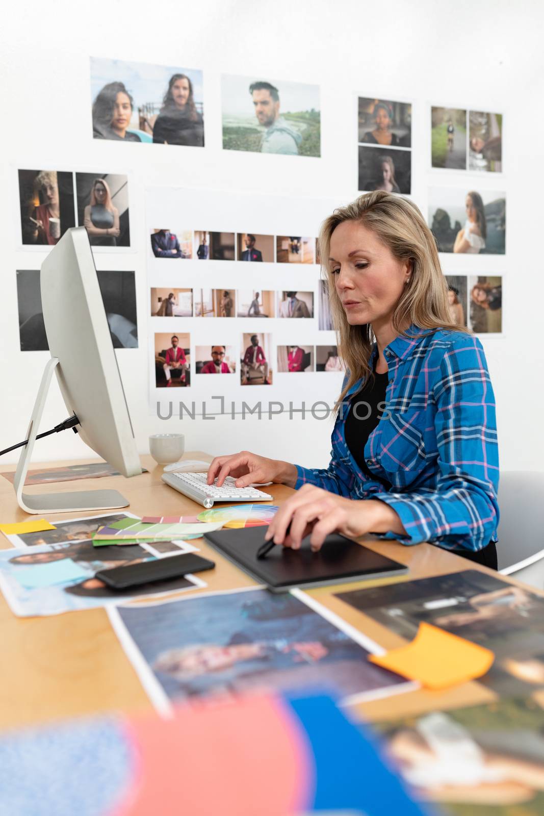 Female fashion designer using graphic tablet at desk by Wavebreakmedia