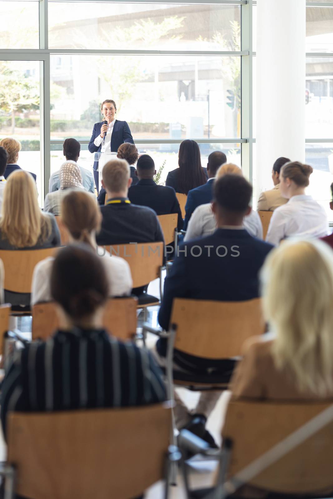 Front view of mature Caucasian businesswoman doing speech in conference room