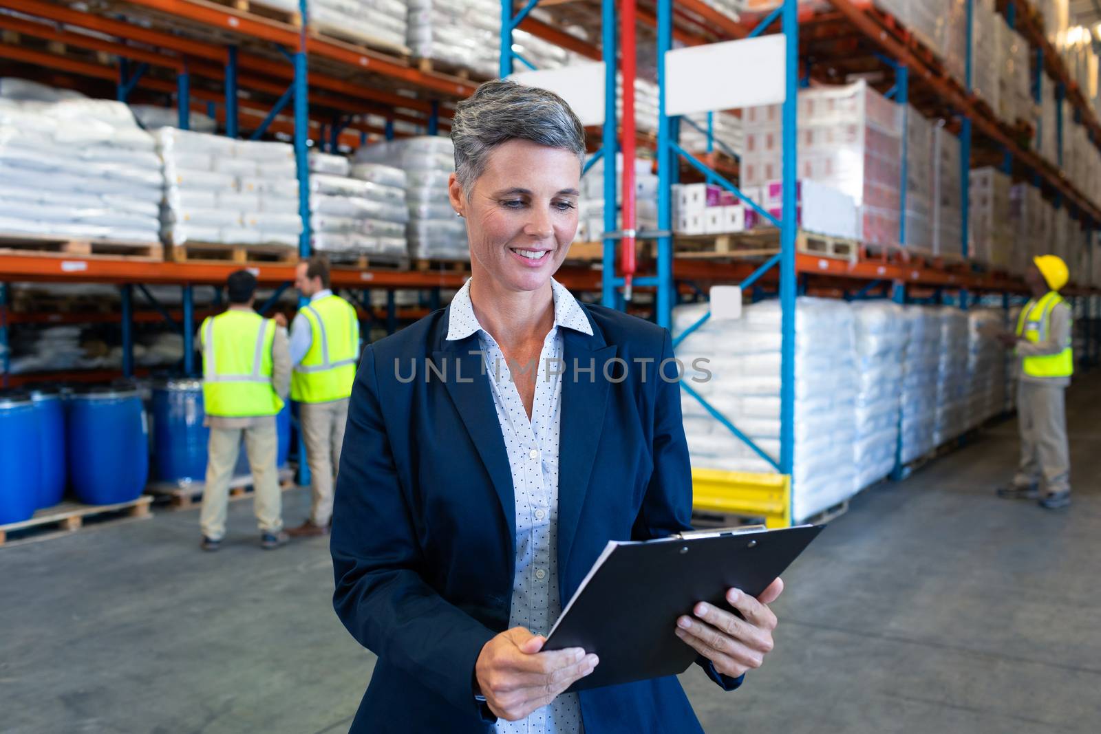 Female manager checking stocks on clipboard in warehouse by Wavebreakmedia