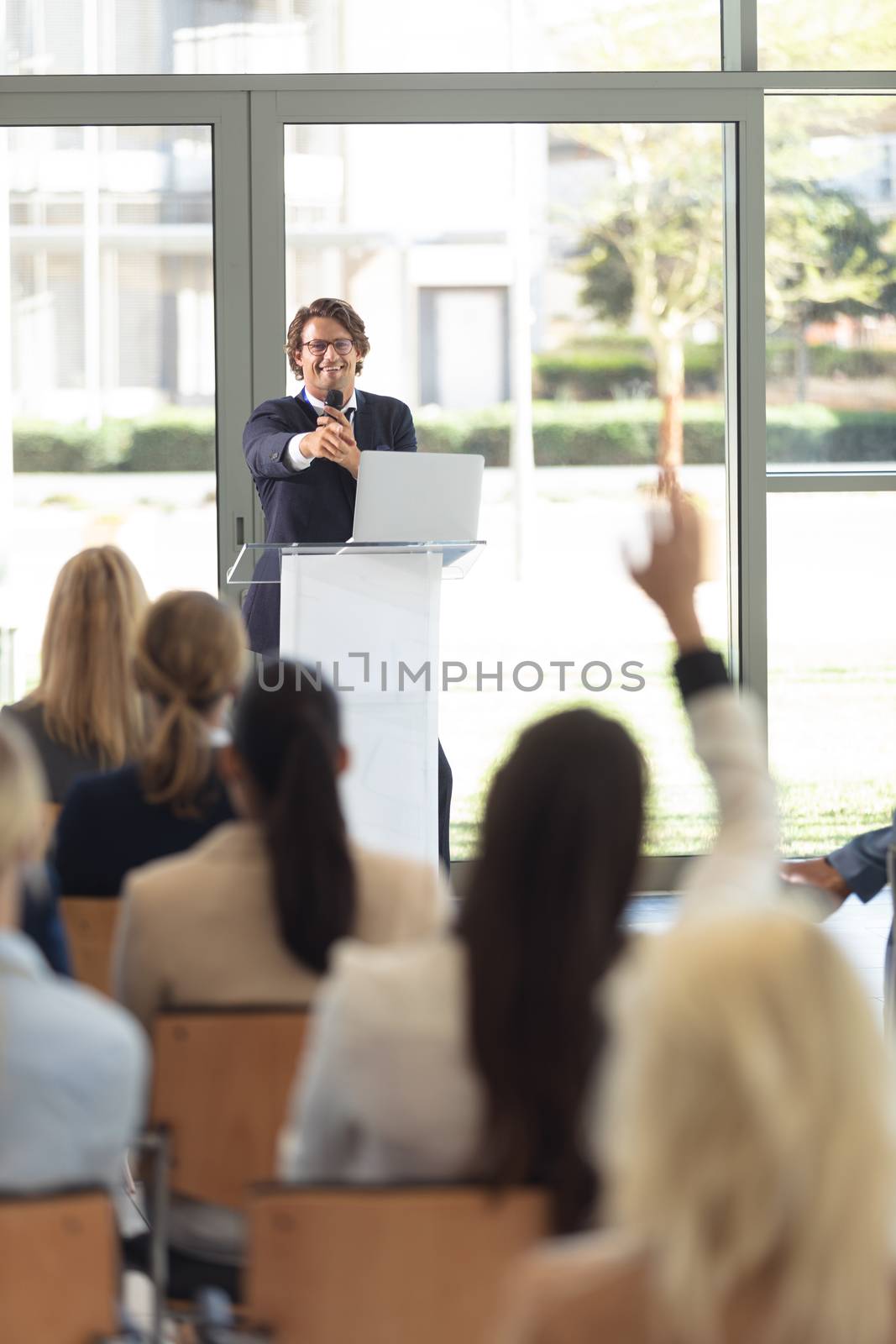 Front view of mature Caucasian male executive doing speech in conference room