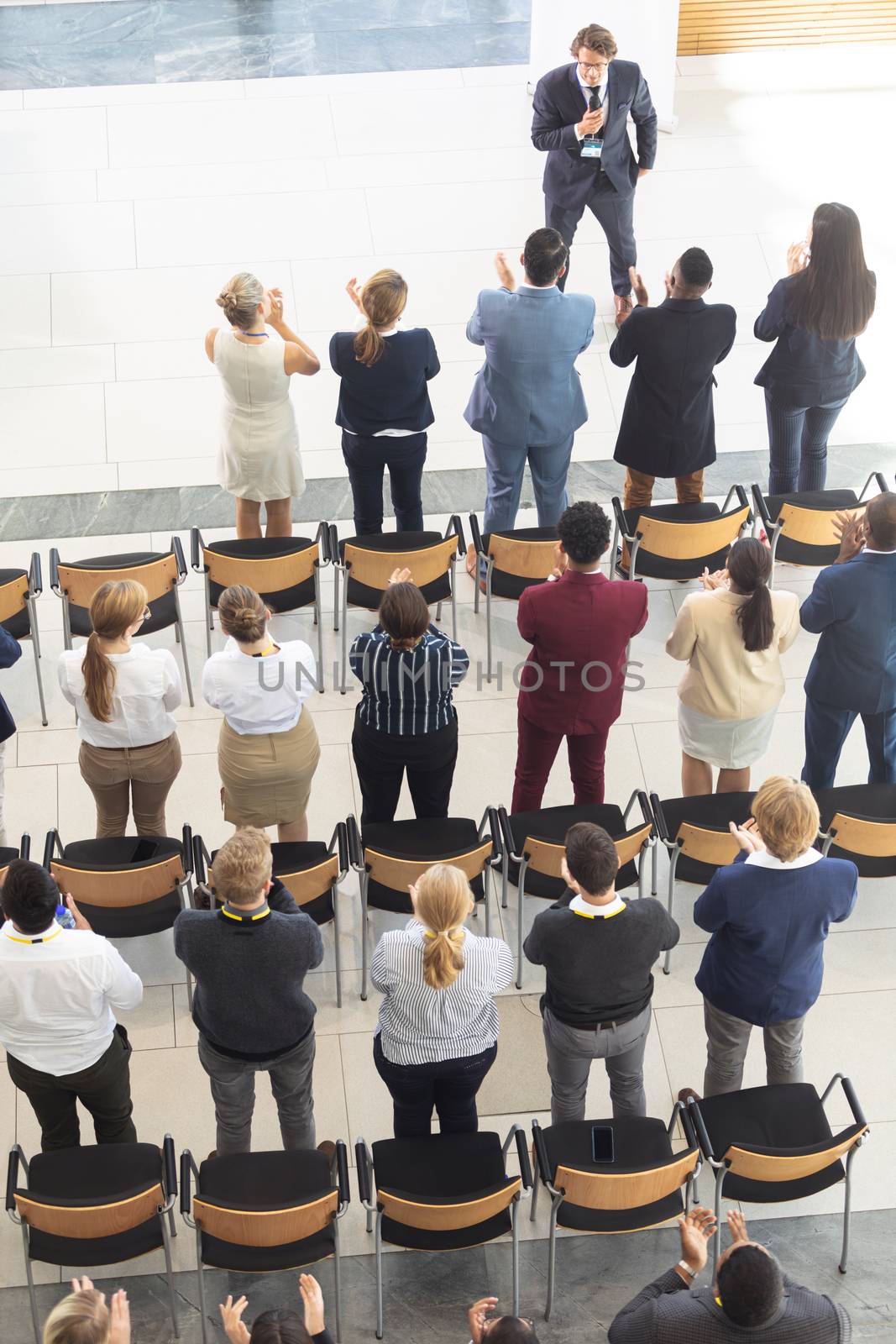 Side view of diverse executives clapping at meeting in conference room