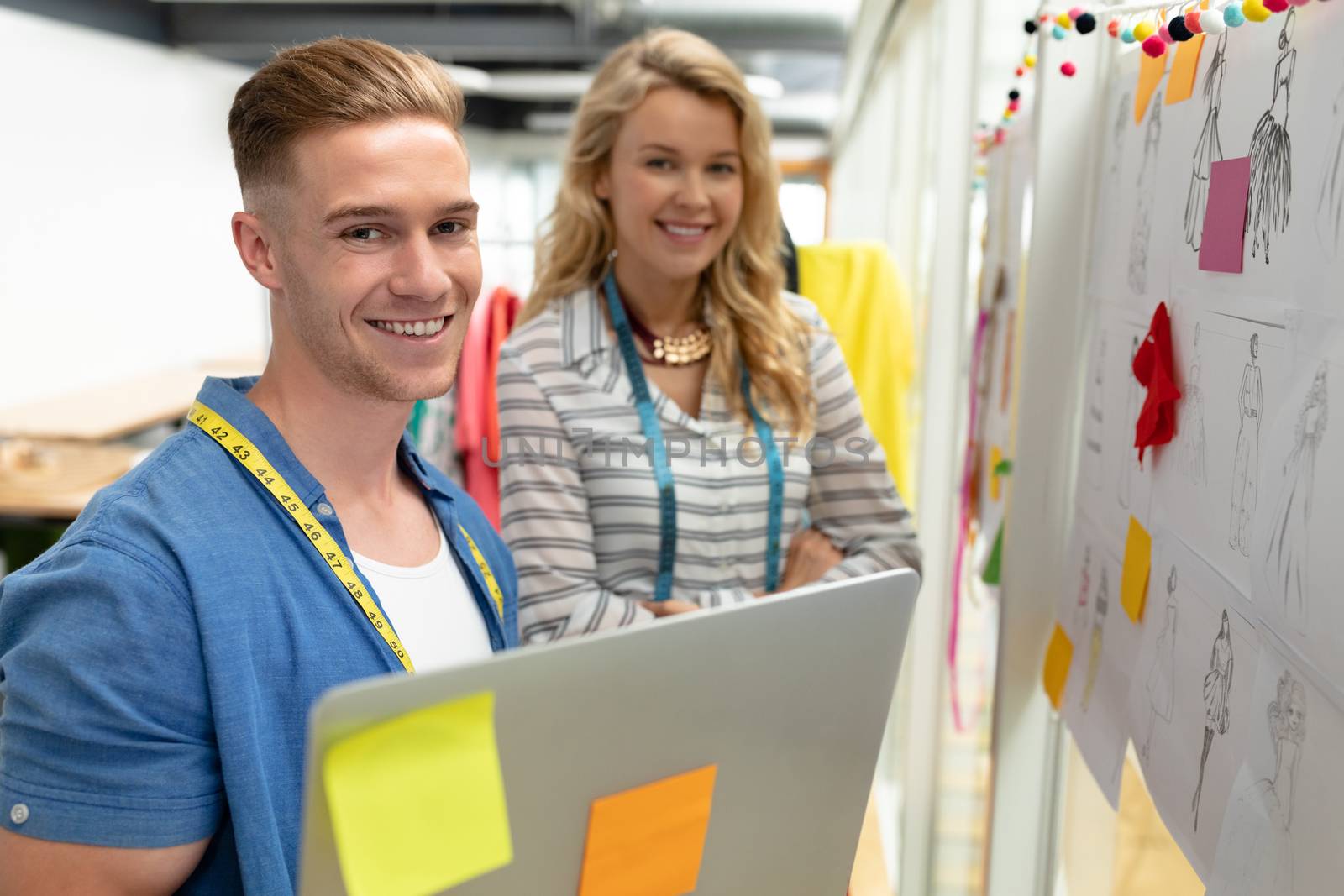 Portrait of Caucasian male and fashion designers smiling in design studio. This is a casual creative start-up business office for a diverse team