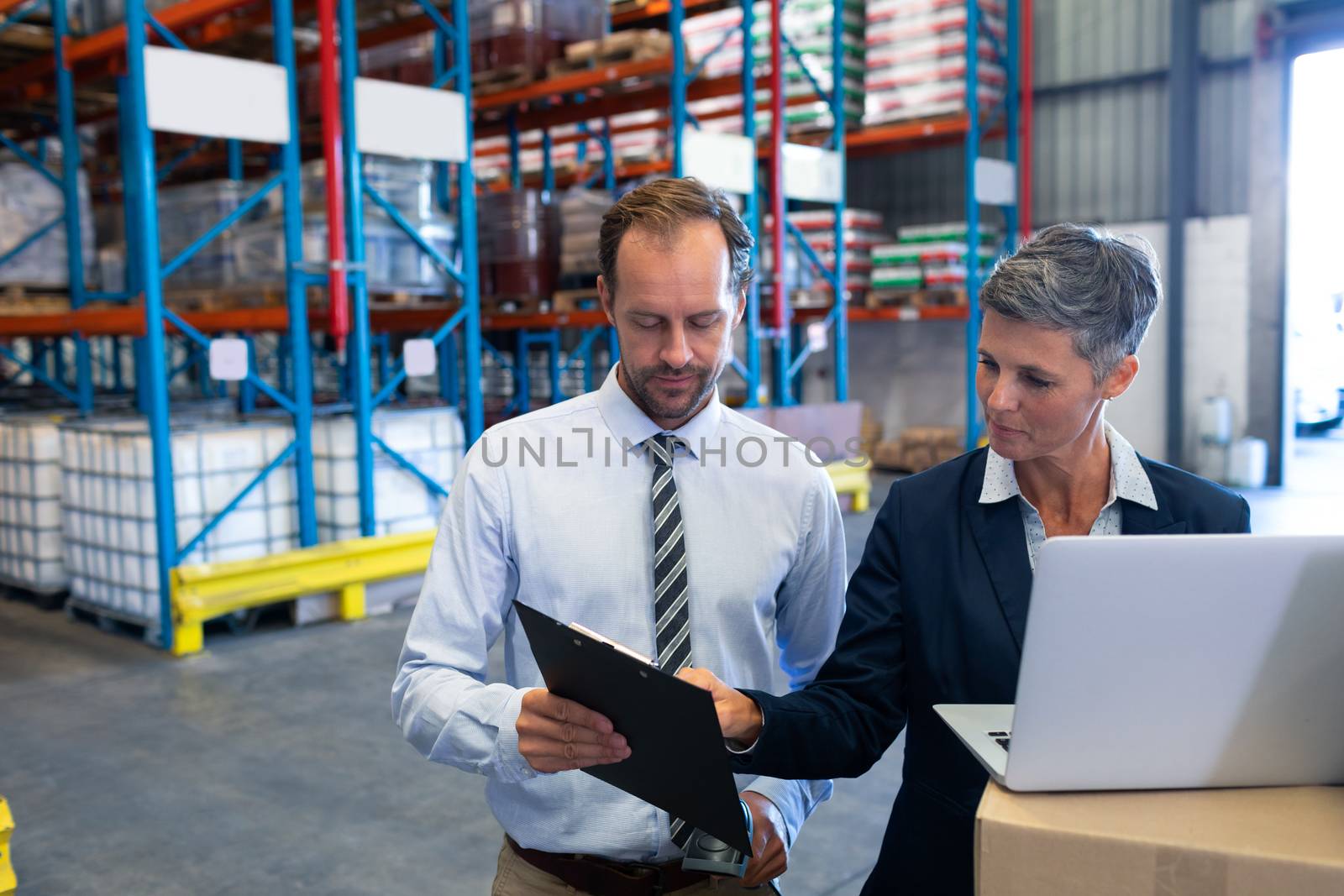 Staffs working together on laptop in warehouse by Wavebreakmedia