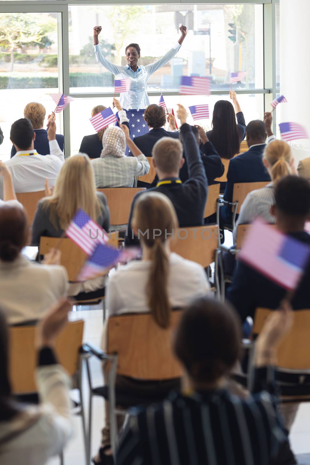 Front view of young African american businesswoman doing speech and celebrating victory in conference room