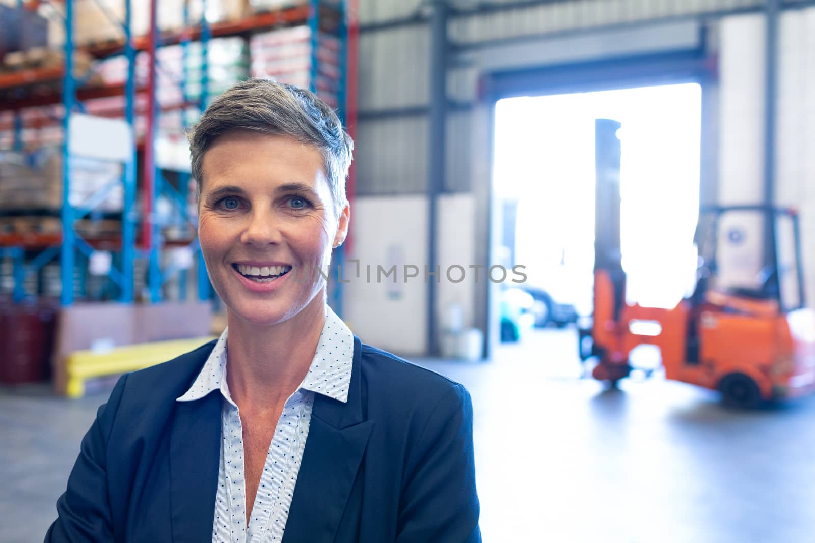 Portrait close-up of beautiful mature Caucasian female manager looking at camera in warehouse. This is a freight transportation and distribution warehouse. Industrial and industrial workers concept