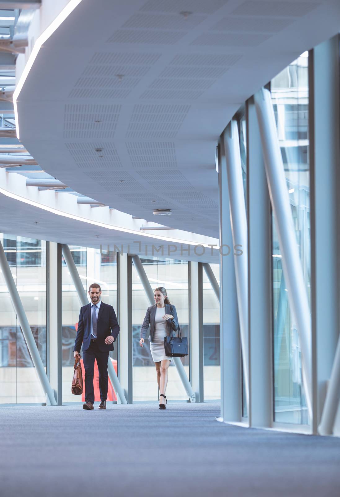 Business people walking together in the corridor at modern office building by Wavebreakmedia