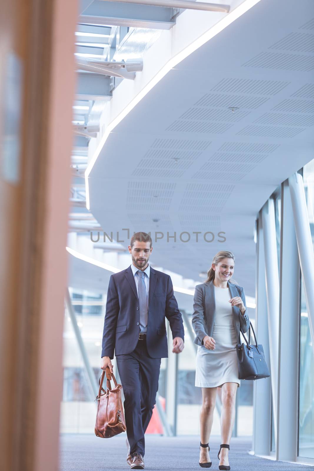 Low angle view of Caucasian business people walking together in the corridor at modern office building
