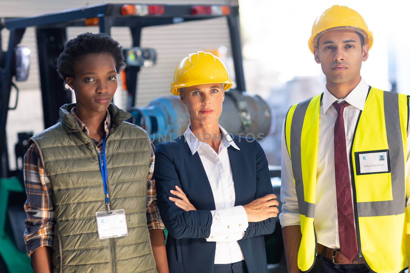 Warehouse staff looking at camera in warehouse by Wavebreakmedia