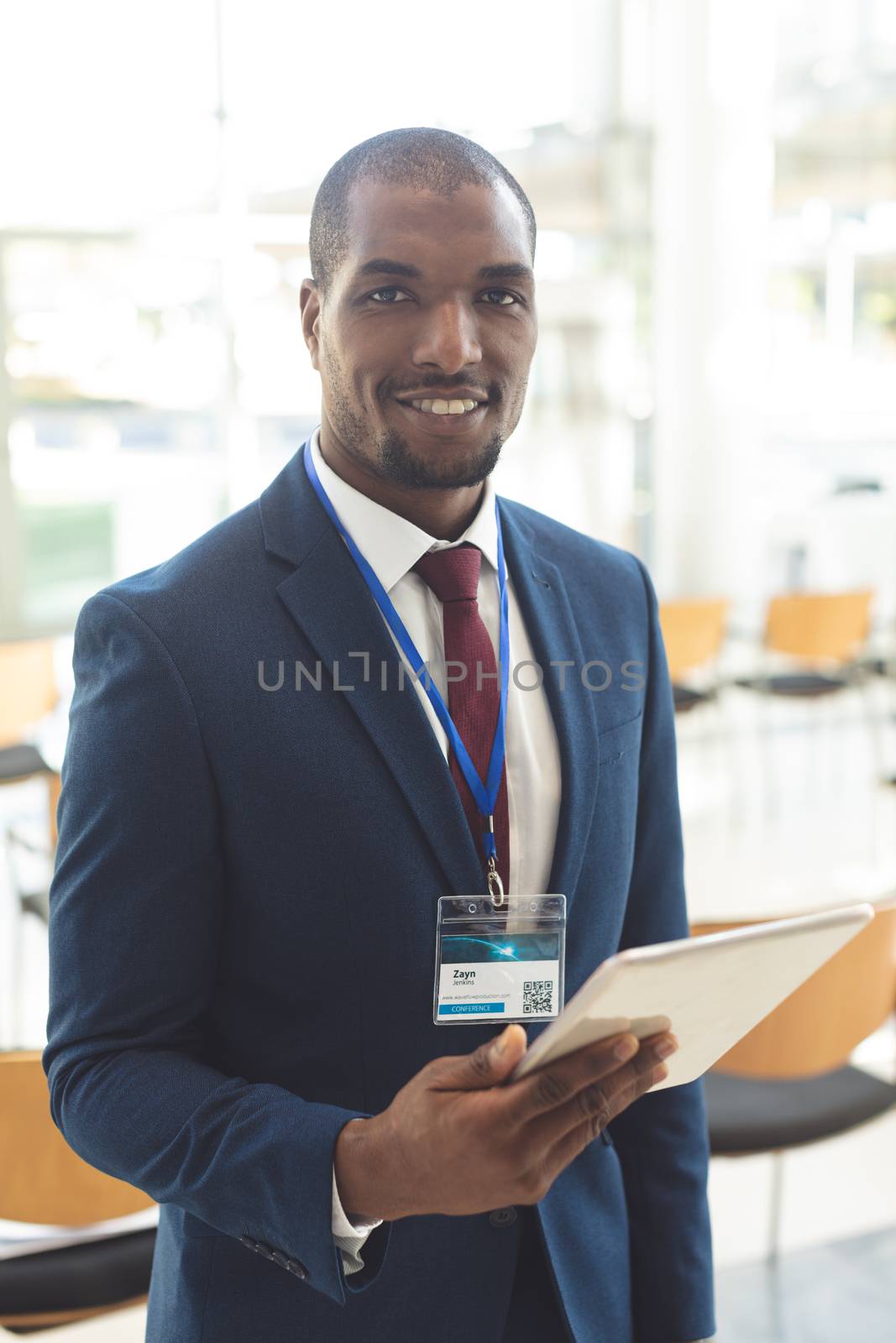 African-american businessman standing in conference room with tablet by Wavebreakmedia