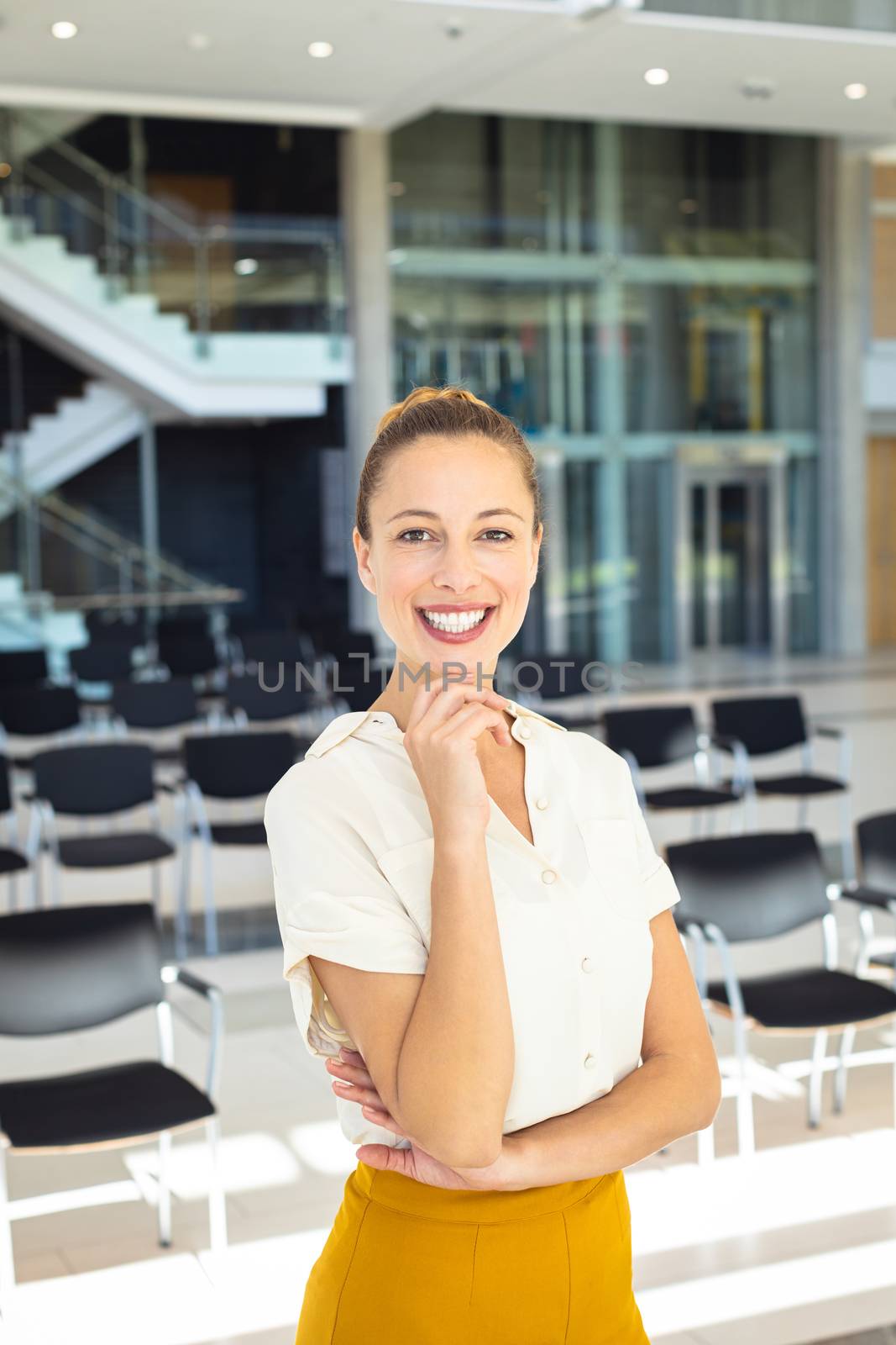 Young Caucasian female executive looking at camera while standing in empty conference room by Wavebreakmedia