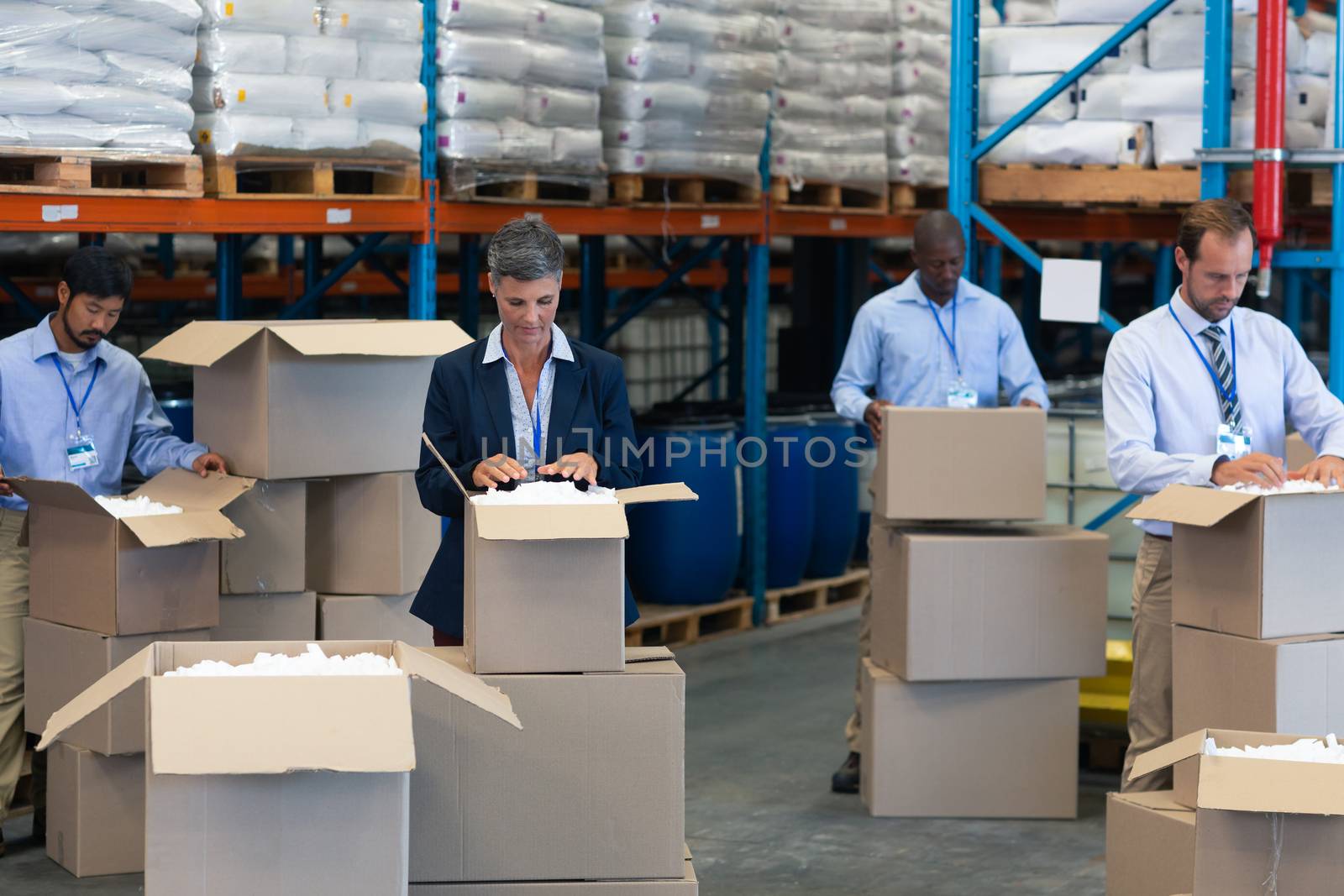 Front view of diverse staff checking stocks in warehouse. This is a freight transportation and distribution warehouse. Industrial and industrial workers concept