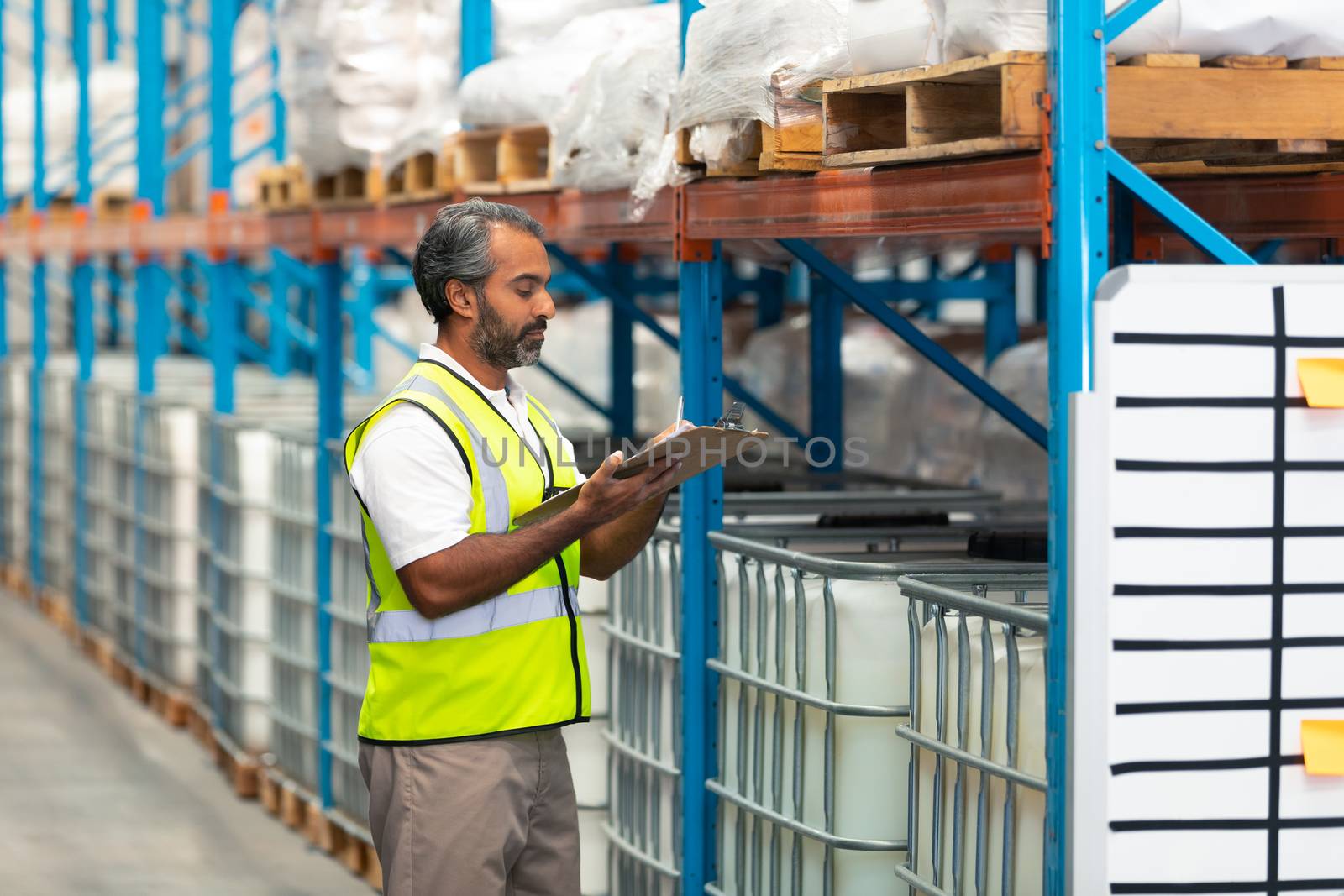 Male worker checking stocks in warehouse by Wavebreakmedia