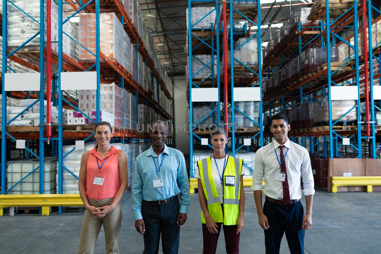 Portrait of confident diverse warehouse staffs standing together in warehouse. This is a freight transportation and distribution warehouse. Industrial and industrial workers concept