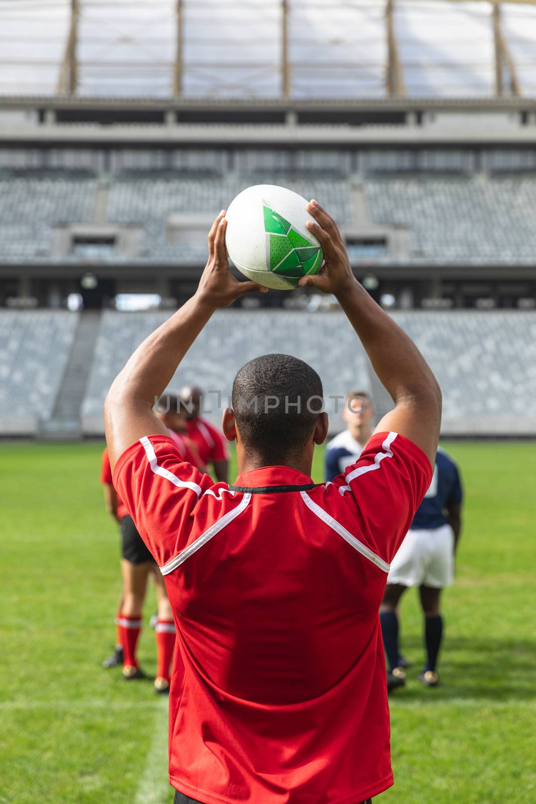 Male rugby player throwing rugby ball in stadium by Wavebreakmedia
