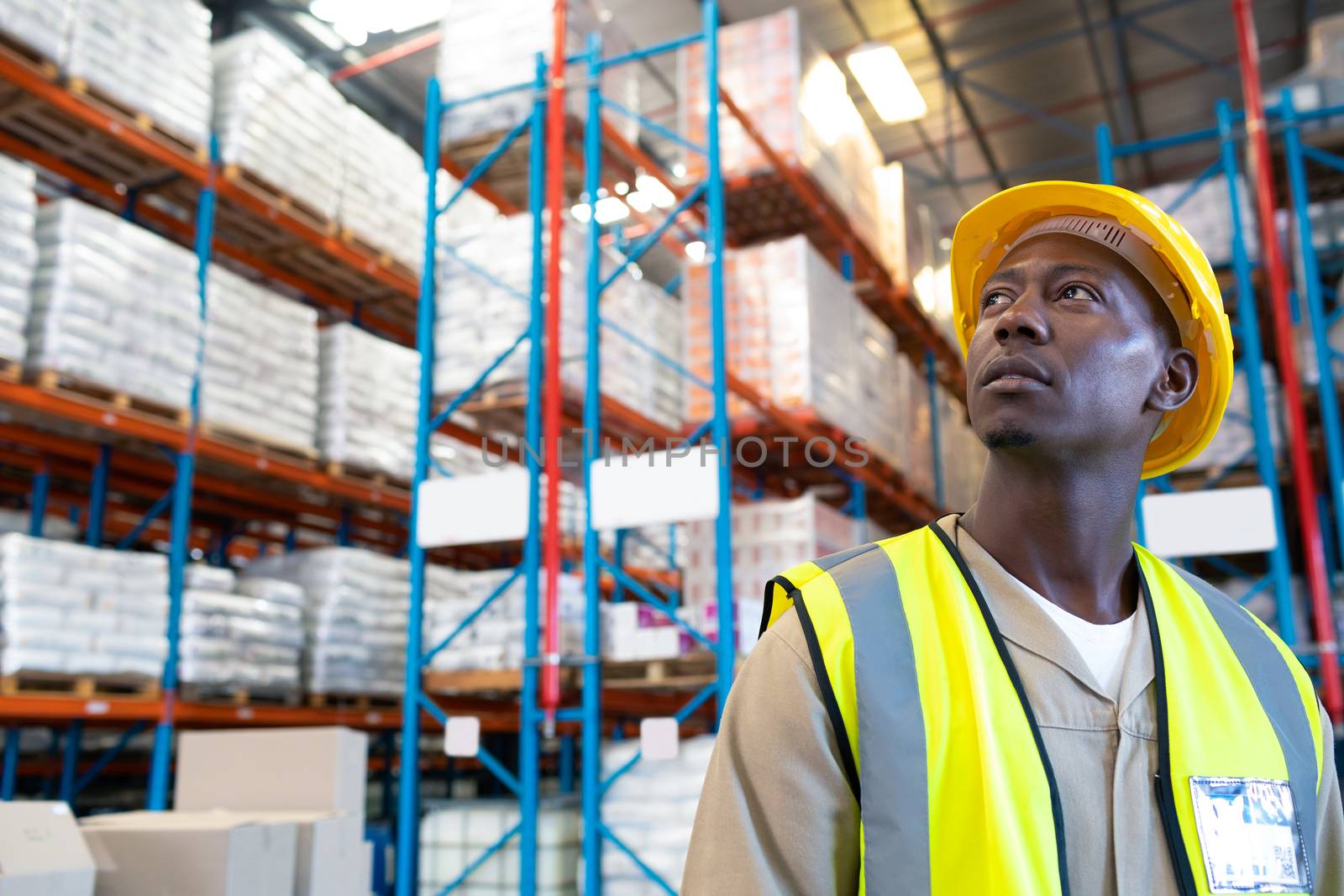 Thoughtful male worker looking away in warehouse by Wavebreakmedia