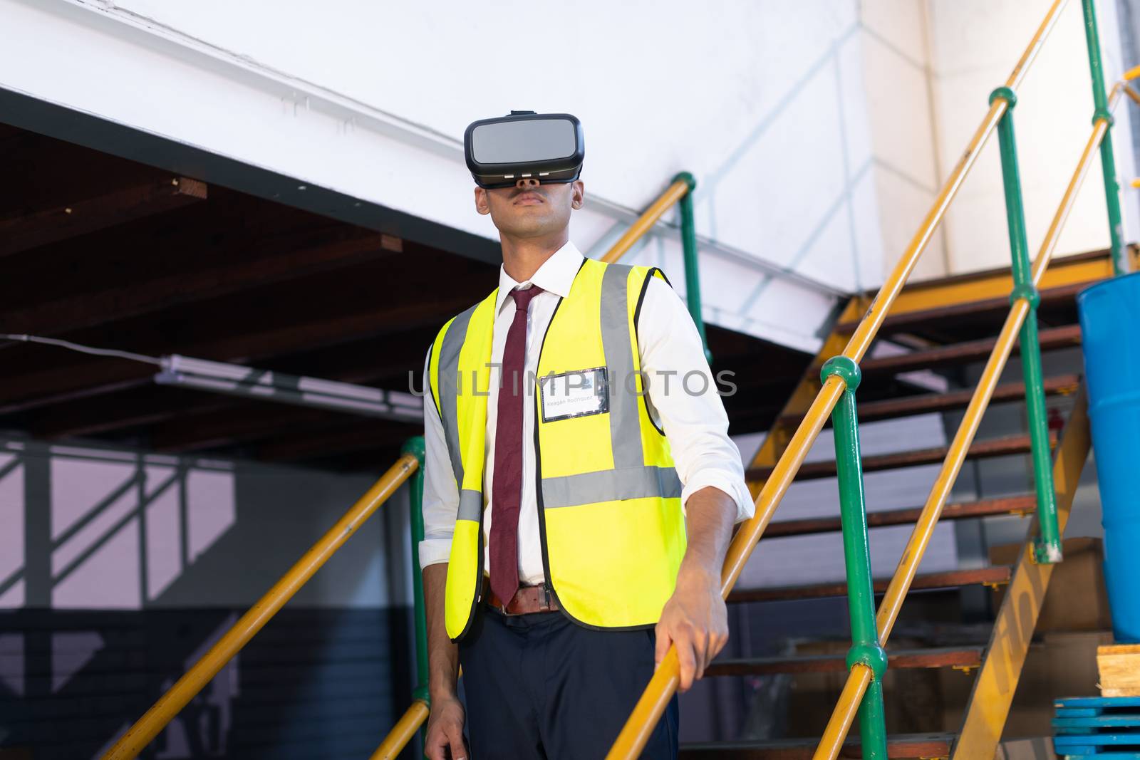 Front view of young Caucasian male supervisor using virtual reality headset in warehouse. This is a freight transportation and distribution warehouse. Industrial and industrial workers concept