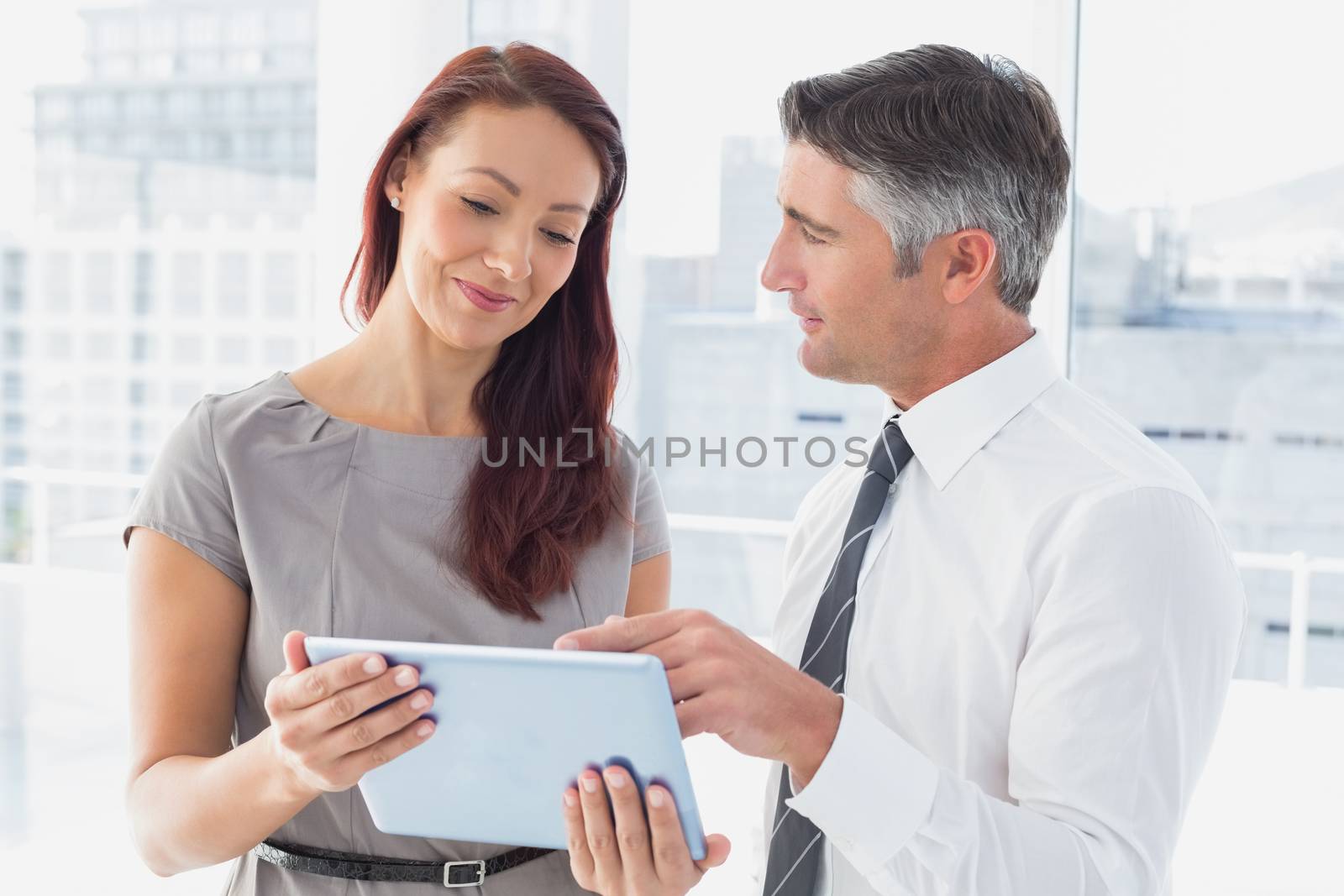 Business people holding a tablet and checking notes
