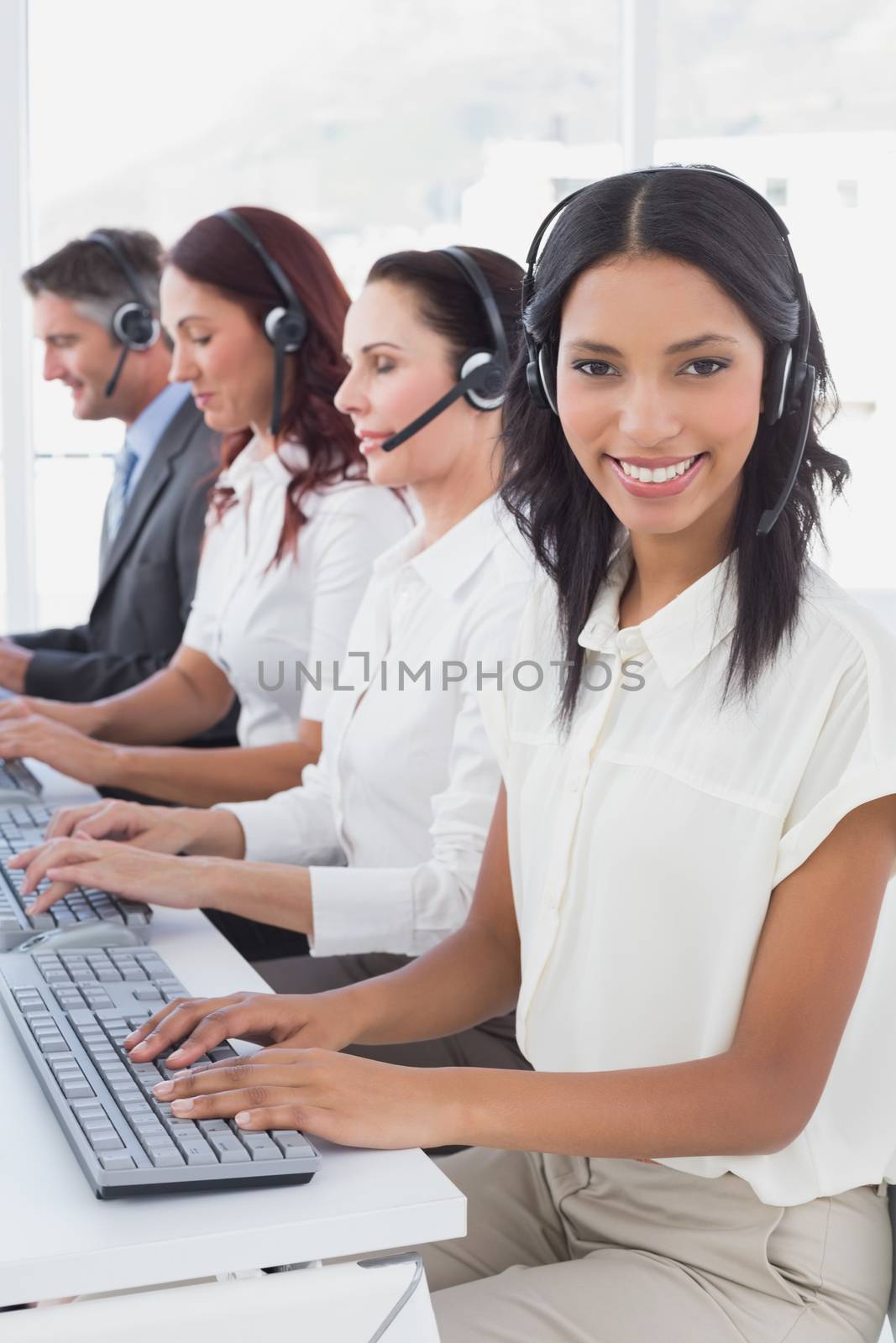 Employees typing on their computers using headsets