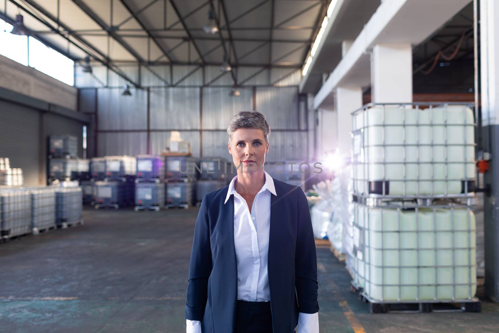 Portrait of Caucasian mature female manager standing in warehouse. This is a freight transportation and distribution warehouse. Industrial and industrial workers concept