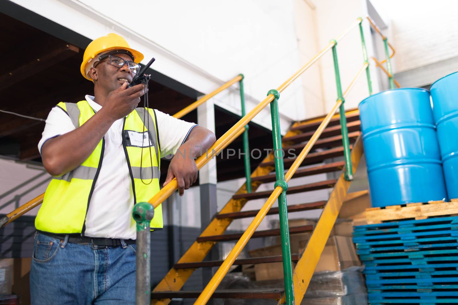 Male worker talking on walkie talkie in warehouse by Wavebreakmedia