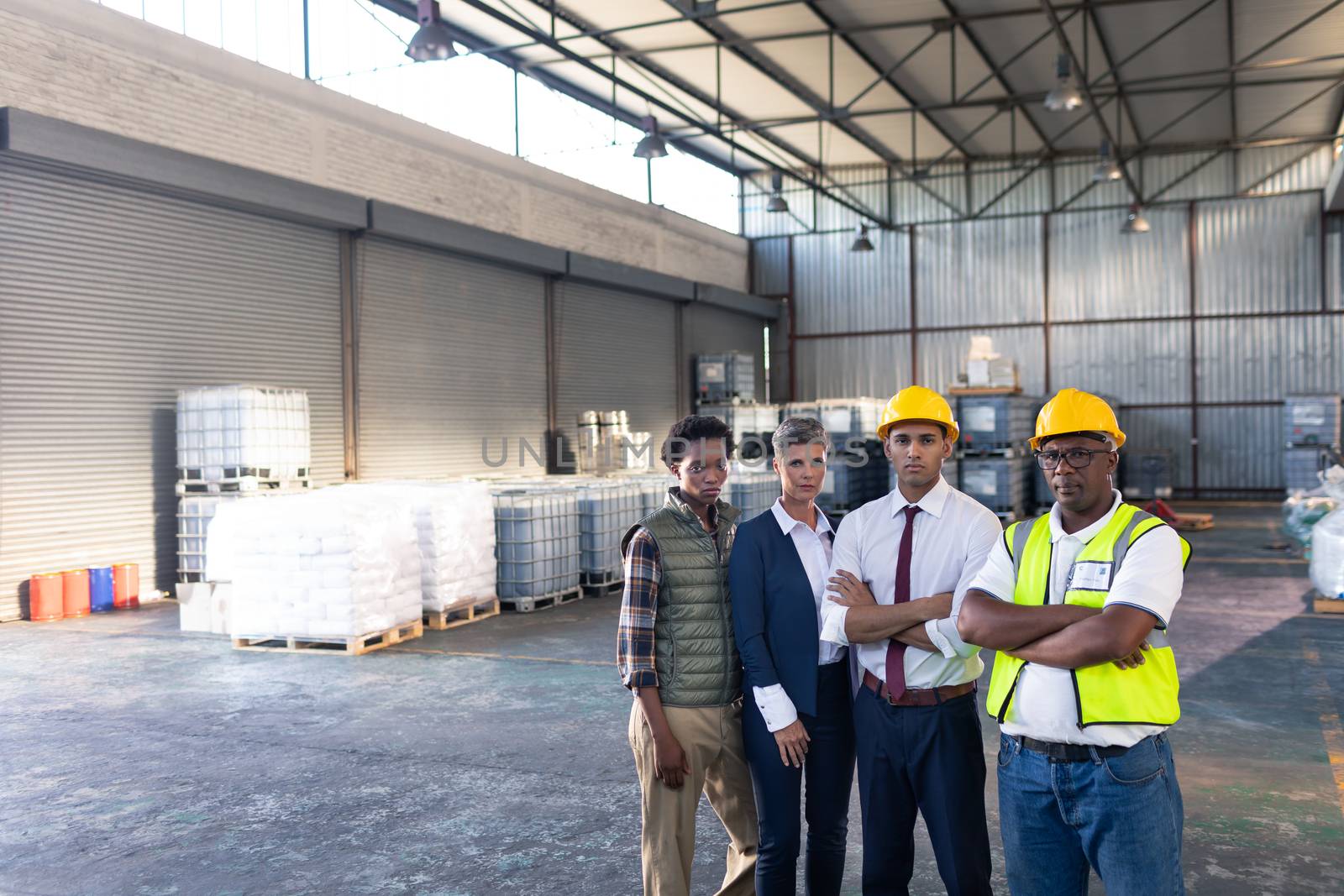 Portrait of diverse male and female staffs standing together in warehouse. This is a freight transportation and distribution warehouse. Industrial and industrial workers concept